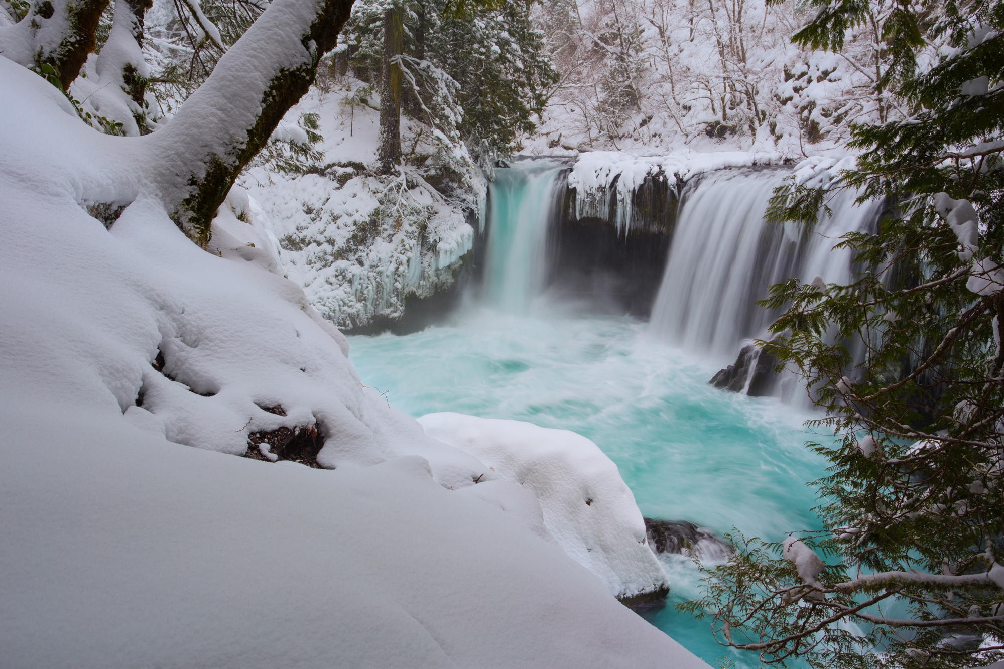 Snowy waterfall with turquoise water in a forest HD Wallpaper