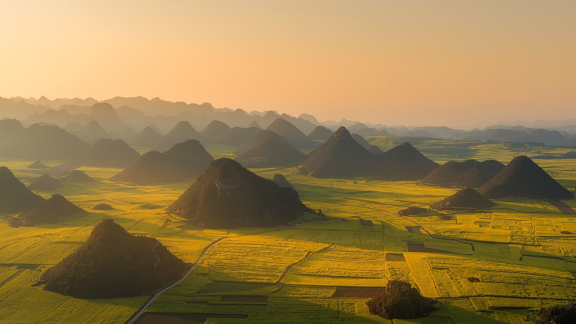 Aerial view of conical hills and yellow fields in China at sunset HD Wallpaper