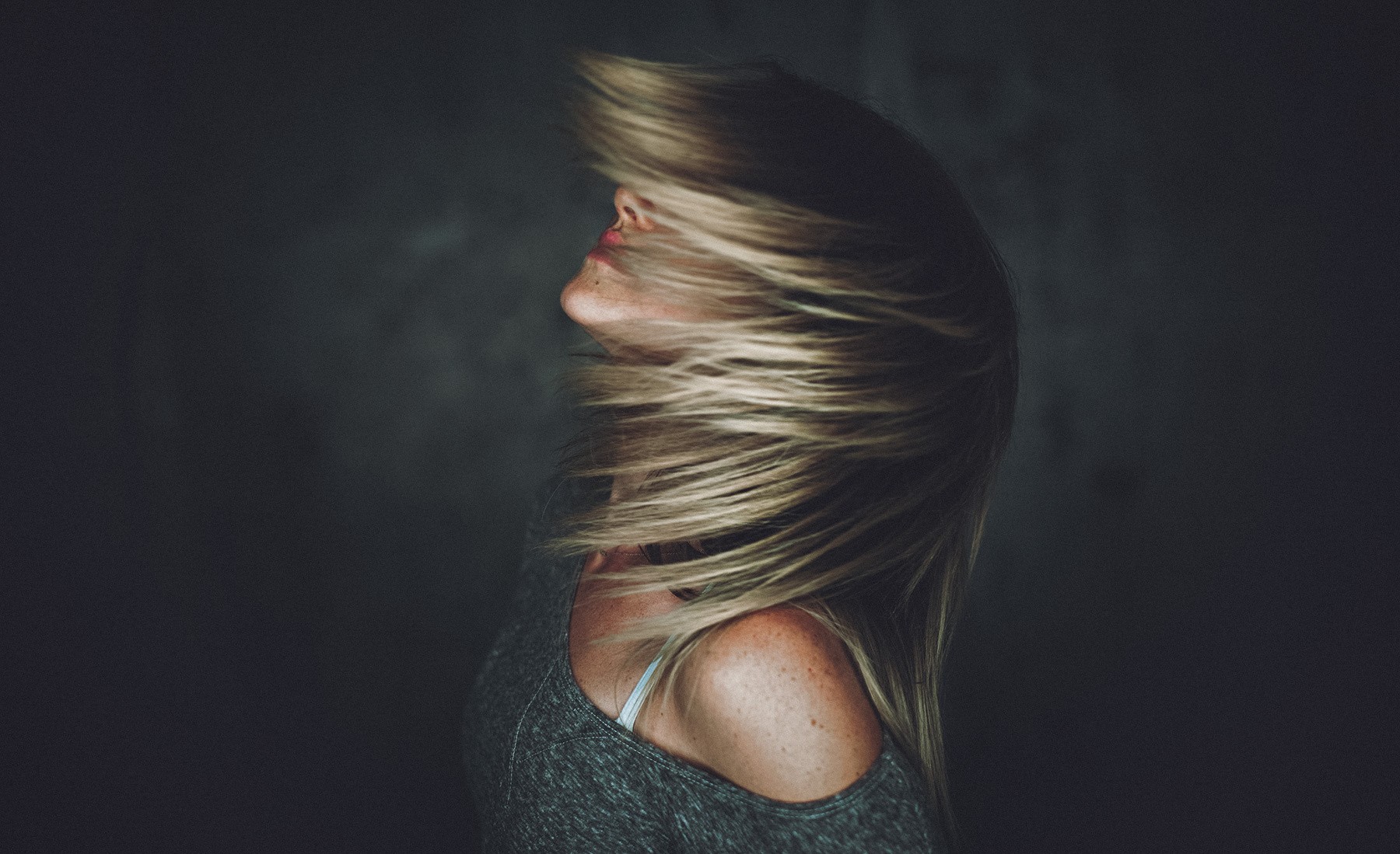 Woman with hair blowing across her face HD Wallpaper