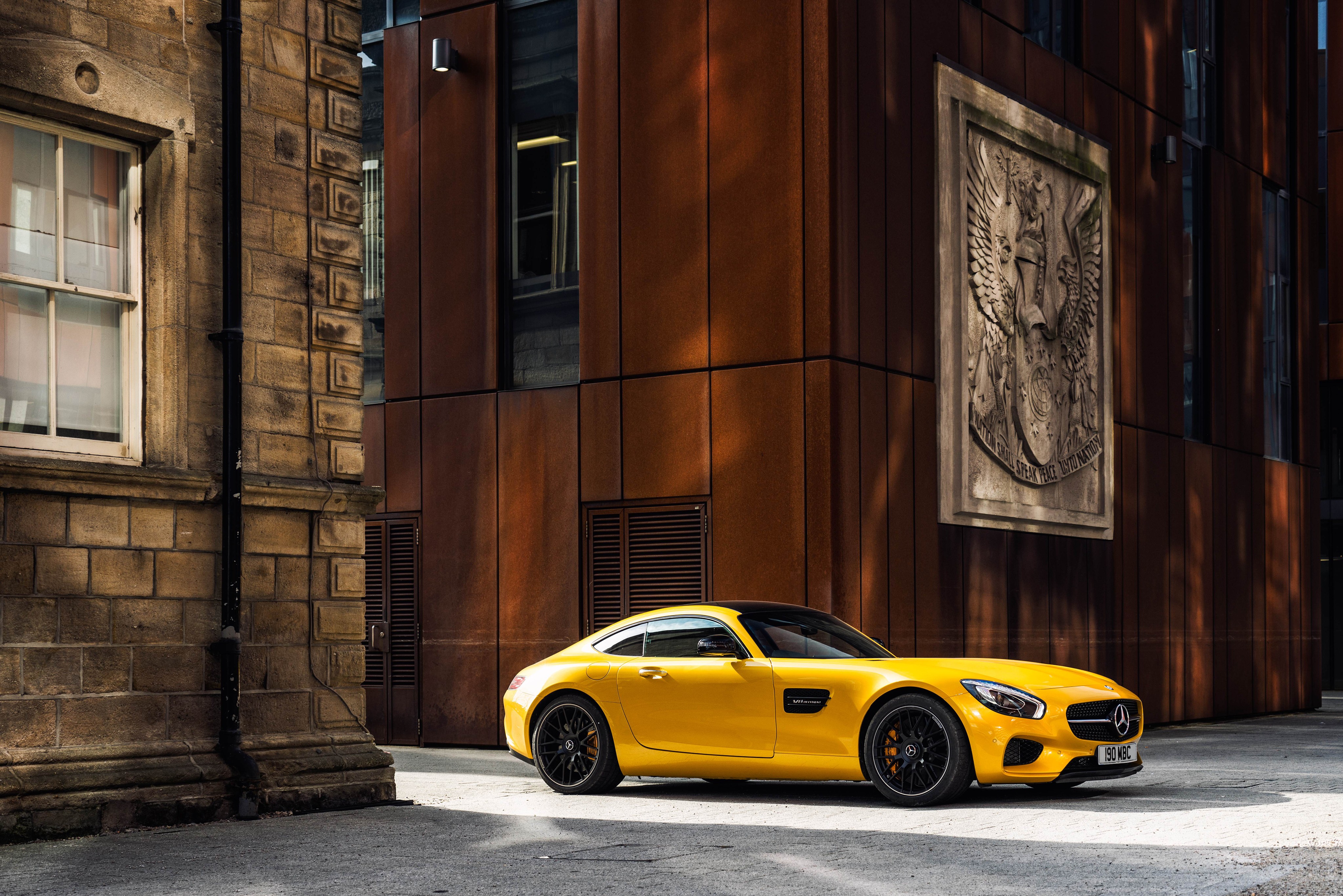 Yellow Mercedes-AMG GT parked near a building HD Wallpaper