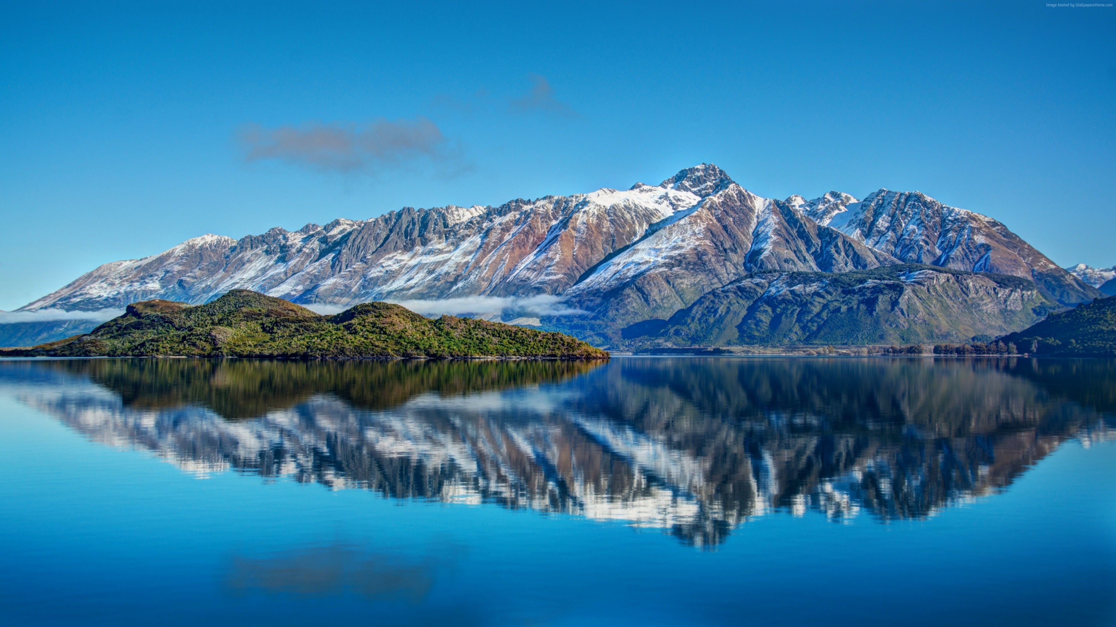 Snow-capped mountains reflected in a calm lake HD Wallpaper