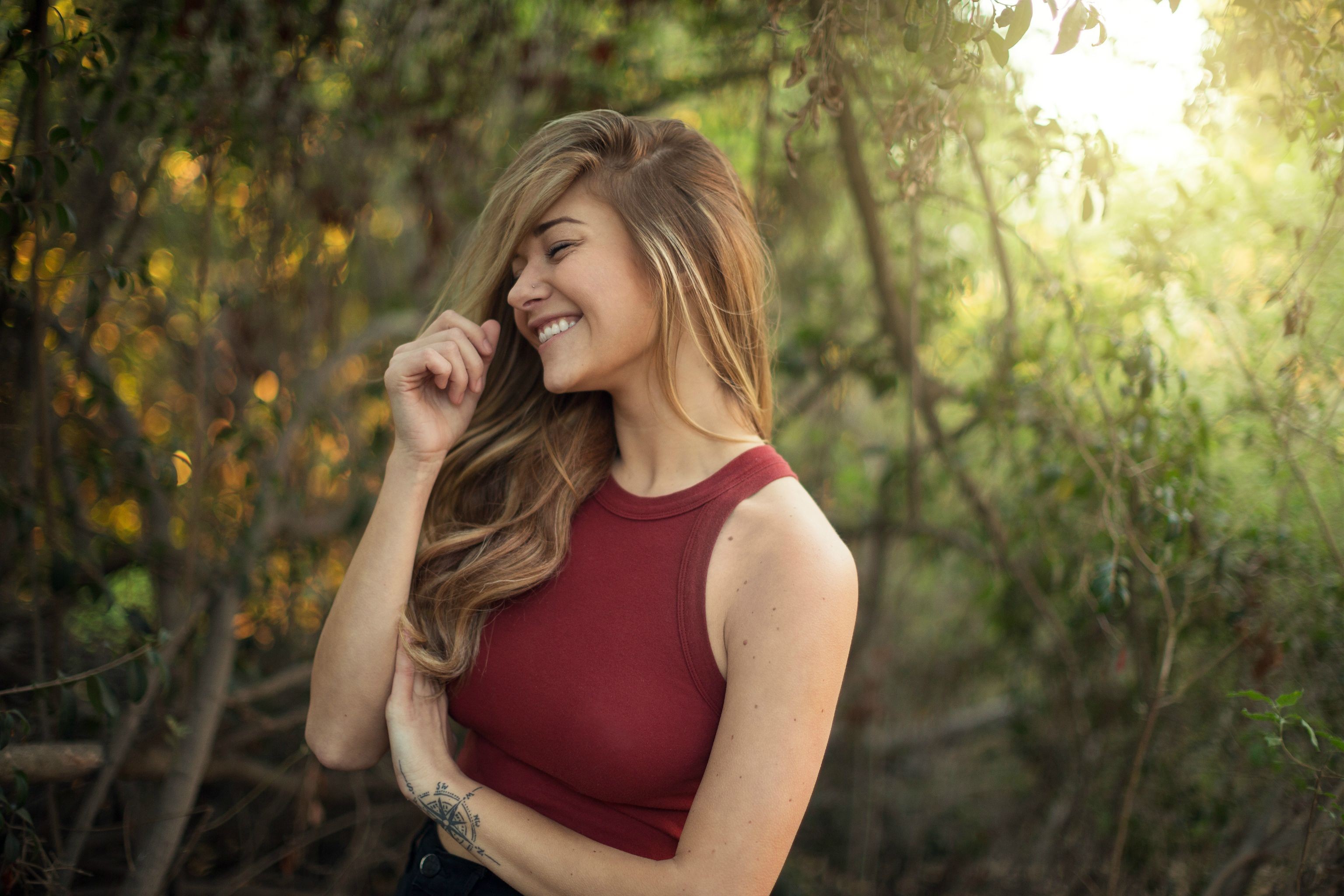 Woman with blonde hair smiling outdoors HD Wallpaper