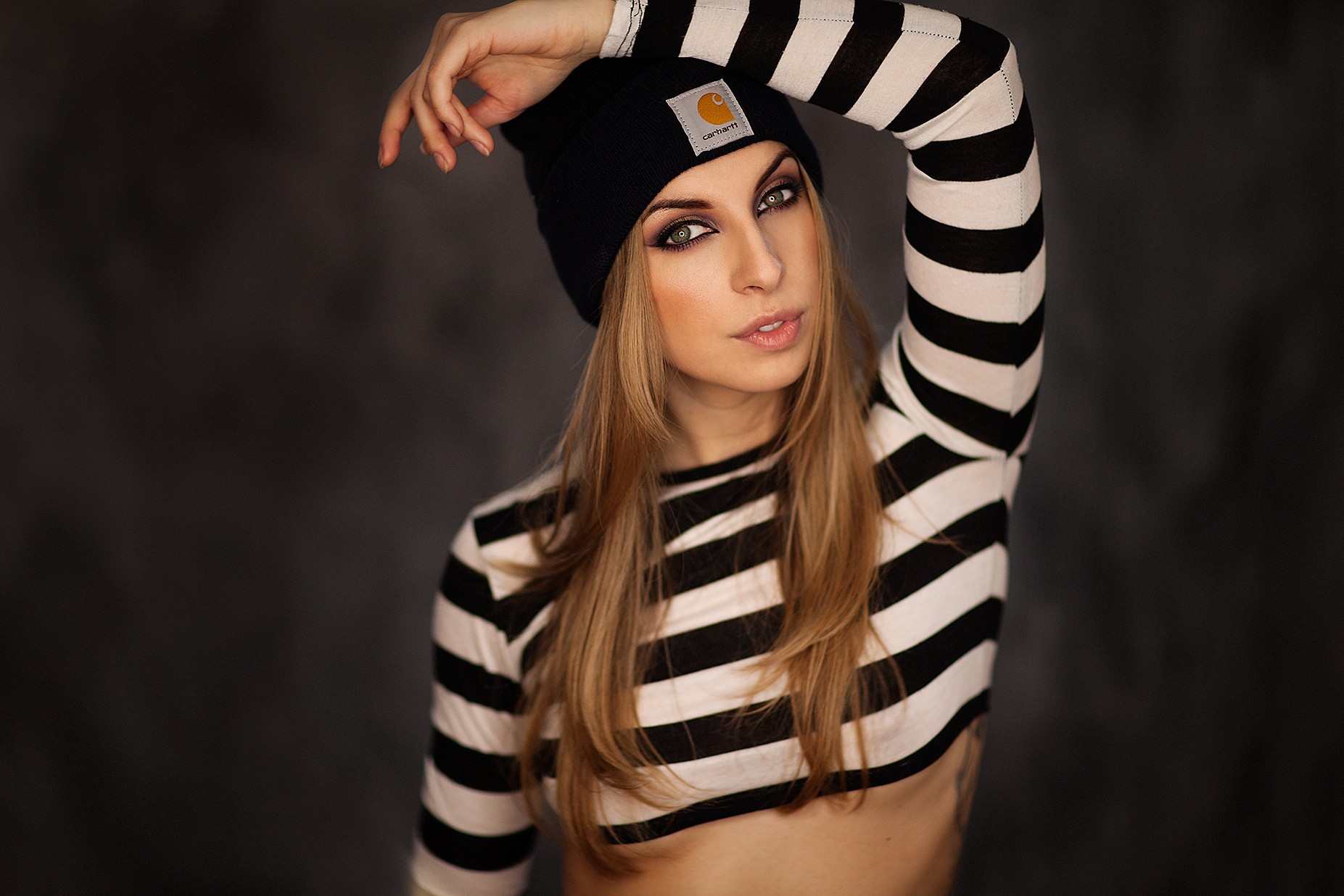 Woman wearing a black Carhartt beanie and striped shirt HD Wallpaper