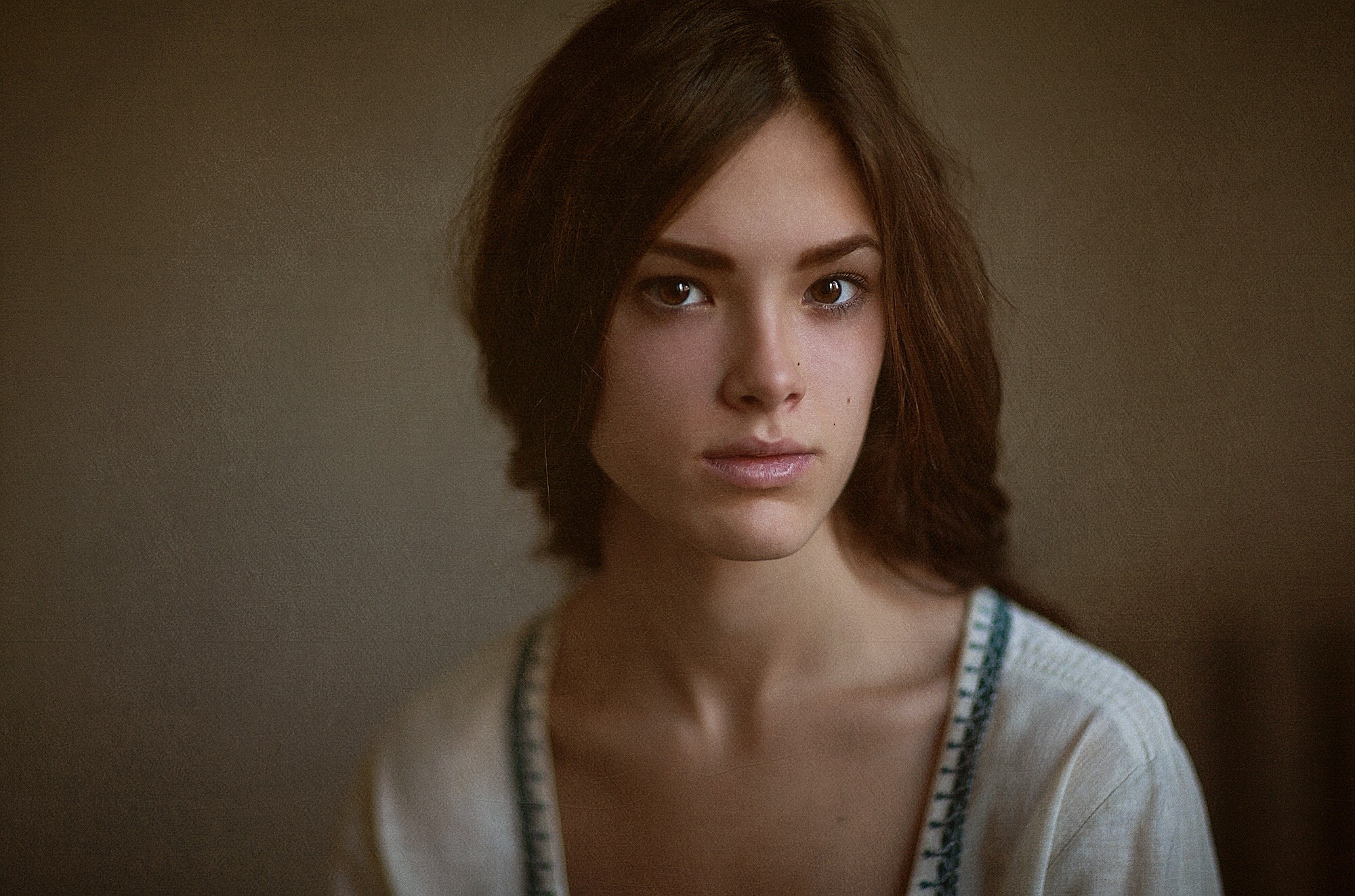 A young woman with brown hair looking at the camera HD Wallpaper