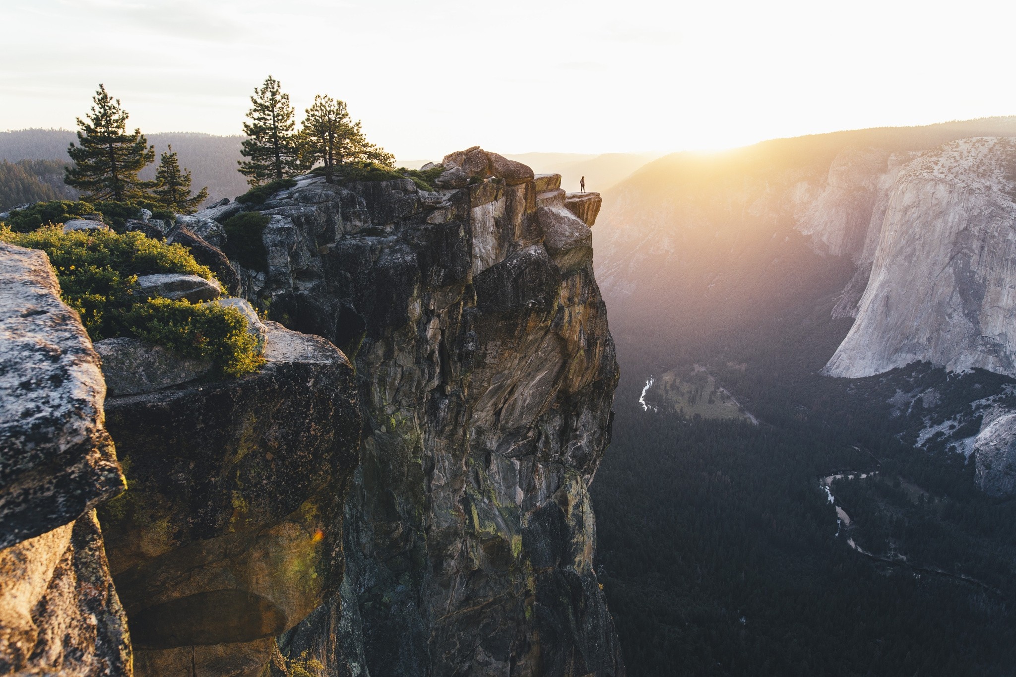 Man standing on cliff edge at Yosemite National Park during sunset HD Wallpaper