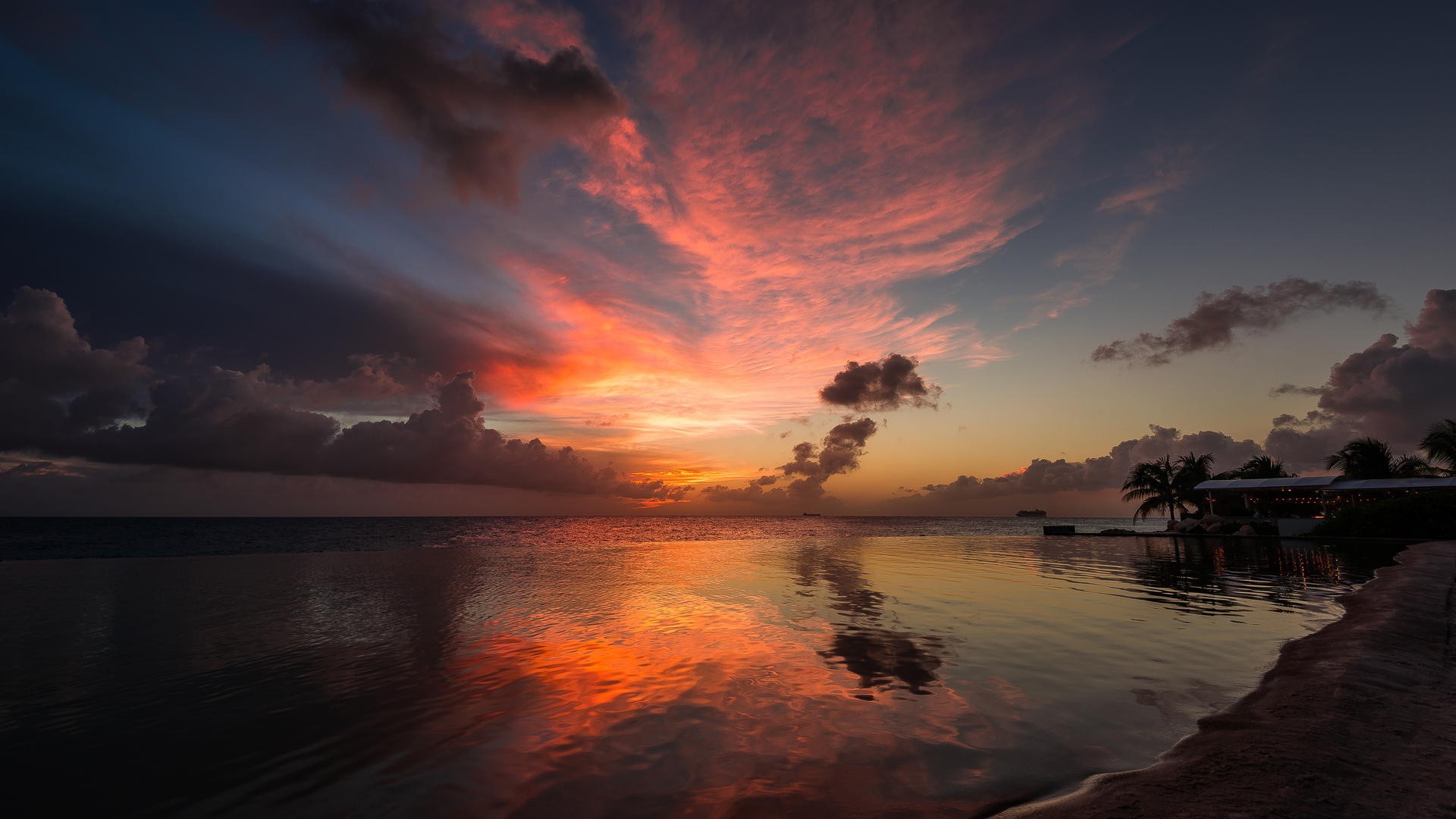 Sunset over the ocean with colorful clouds and reflections HD Wallpaper