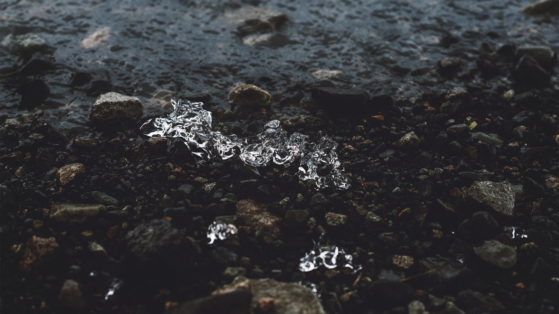 Ice on a rocky shore by the water HD Wallpaper