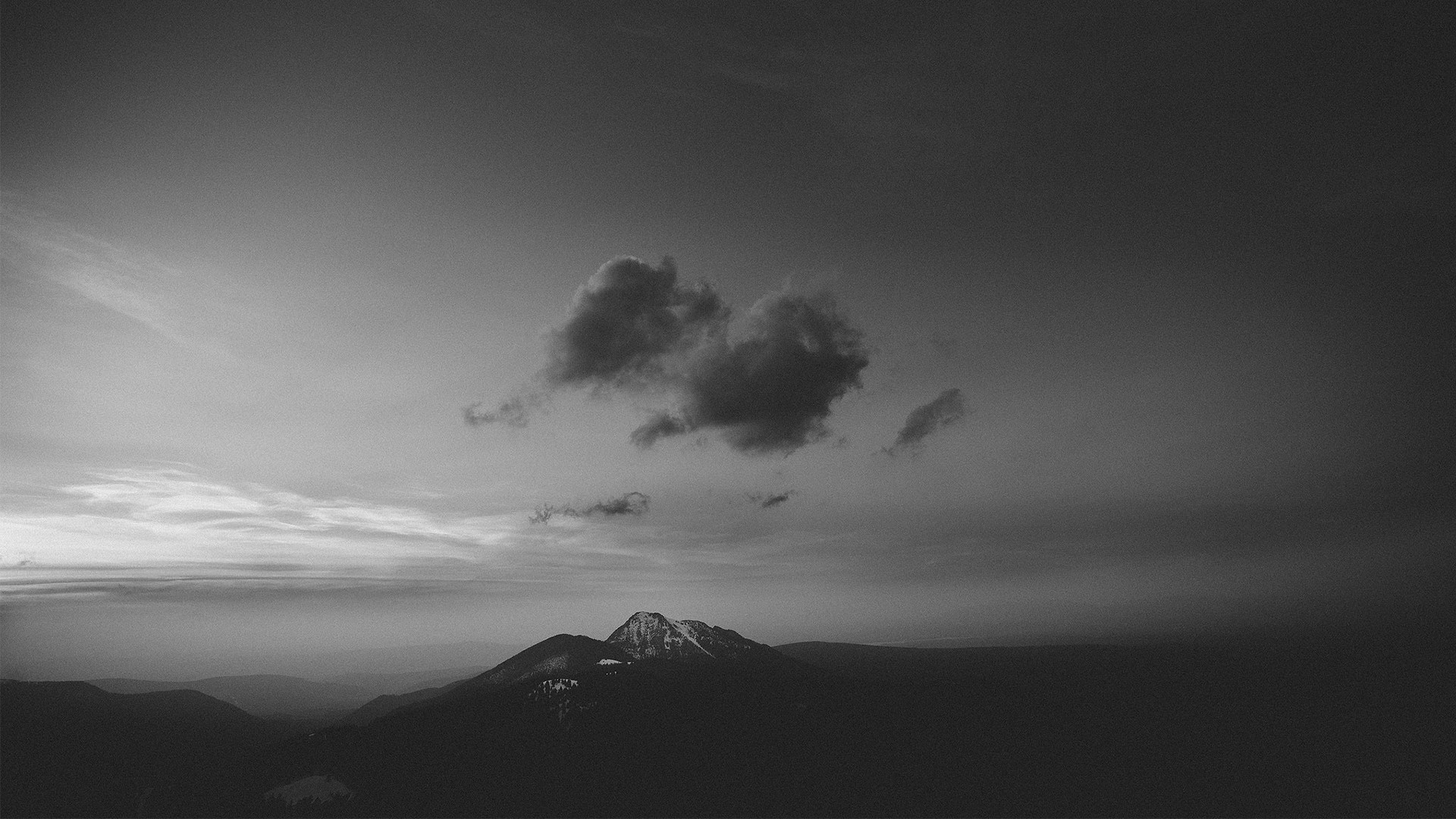 Dark clouds over a snow-capped mountain landscape HD Wallpaper