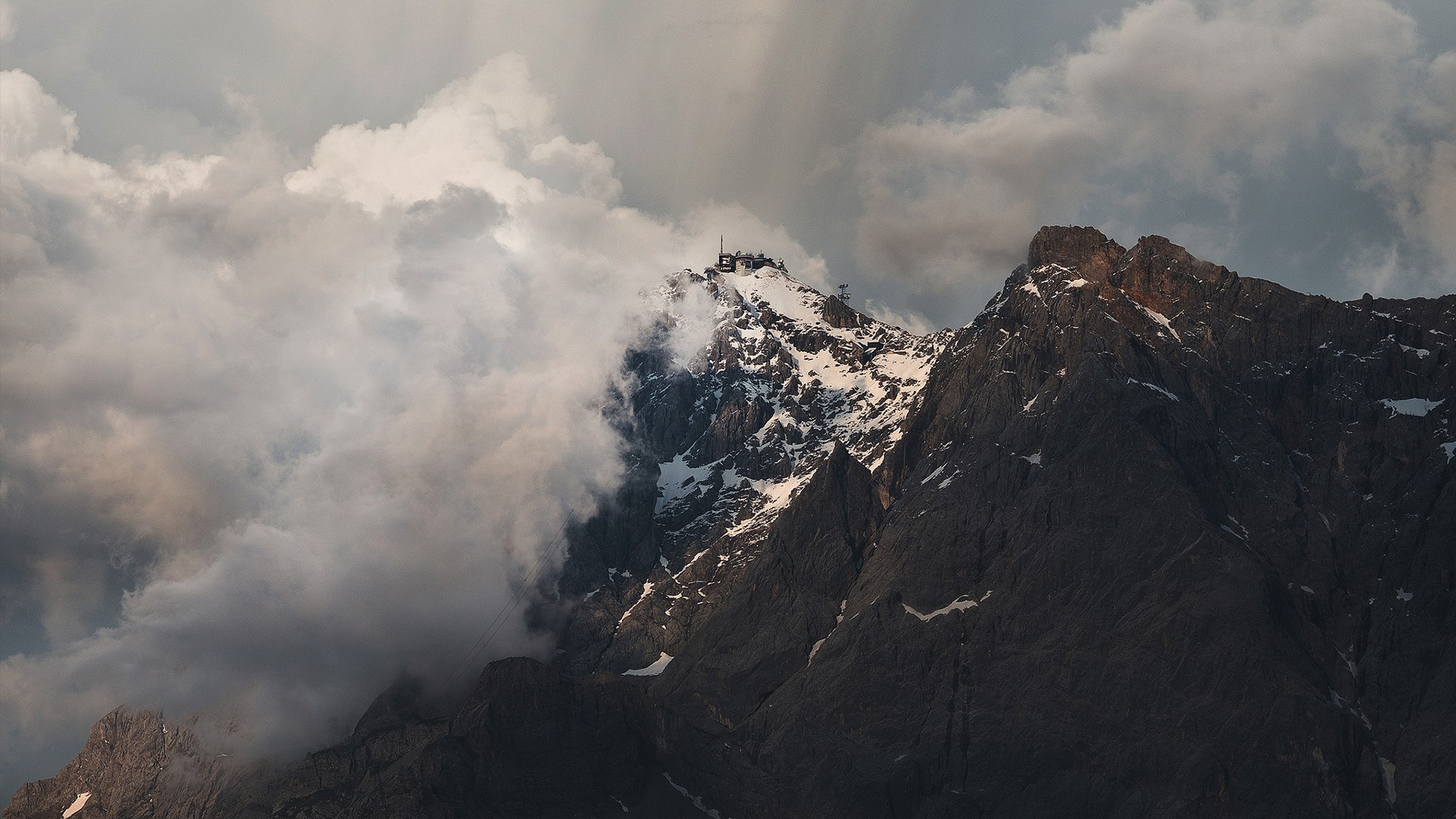 Snow-capped mountain peak with clouds and a structure on top HD Wallpaper