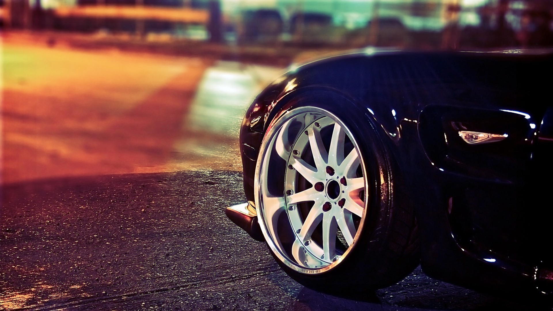 Black sports car with custom rims on a wet road HD Wallpaper