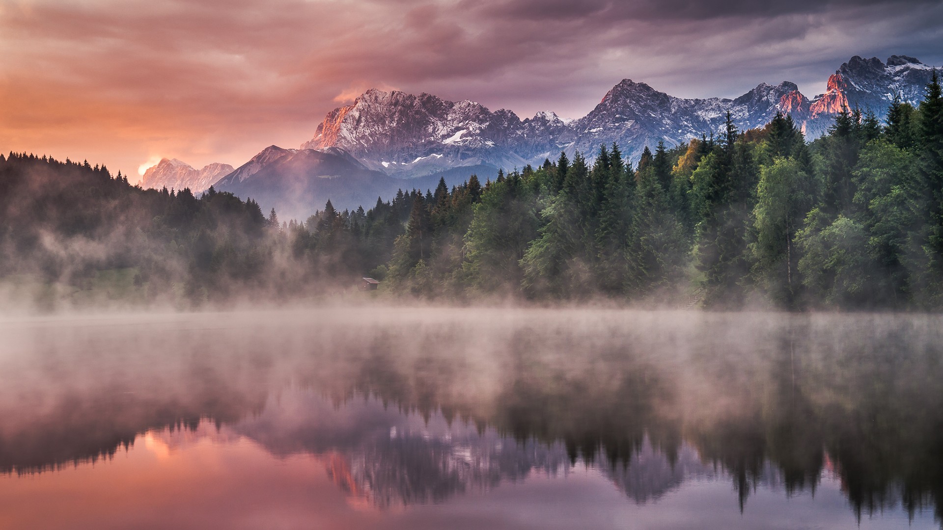 Misty lake reflecting snow-capped mountains and forest HD Wallpaper