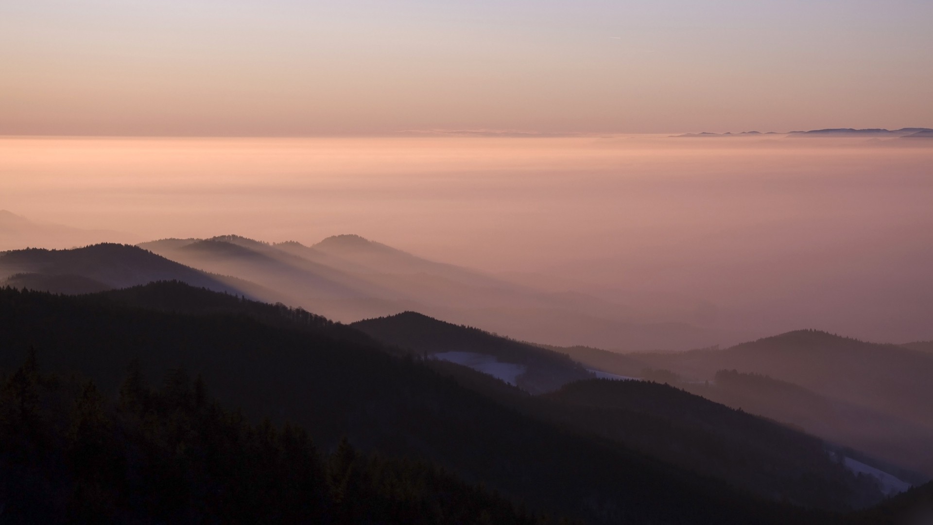 Mountains shrouded in mist at sunset HD Wallpaper