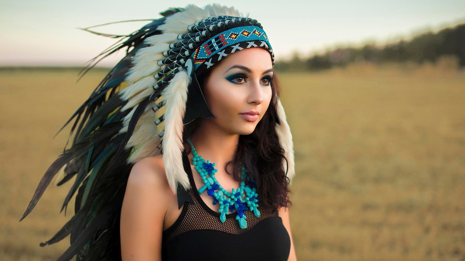 Woman wearing a Native American headdress and necklace HD Wallpaper