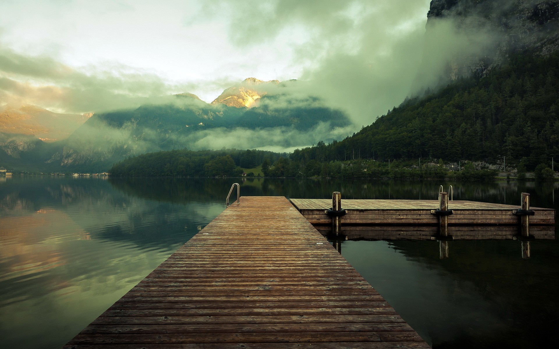 Wooden dock on a misty lake with mountains HD Wallpaper