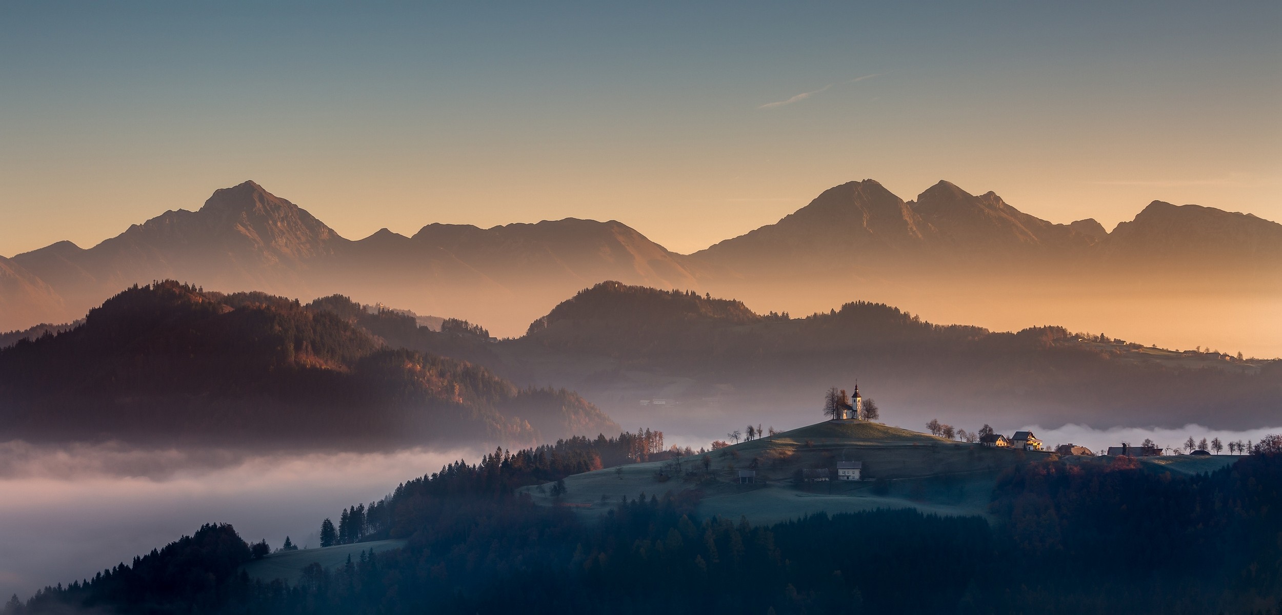 Misty mountains and a village in Slovenia at sunrise HD Wallpaper