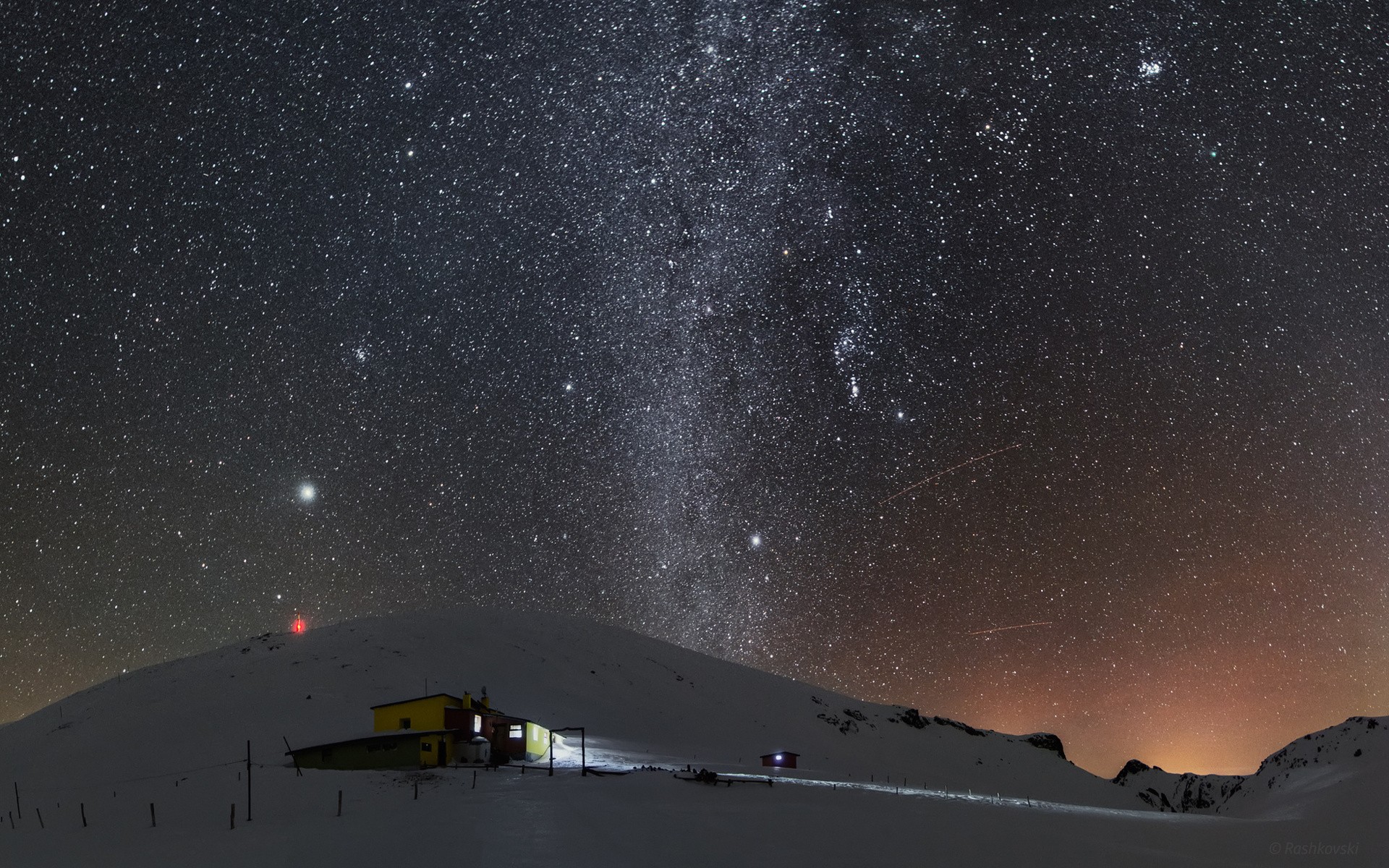 Milky Way over a snowy mountain cabin at night HD Wallpaper
