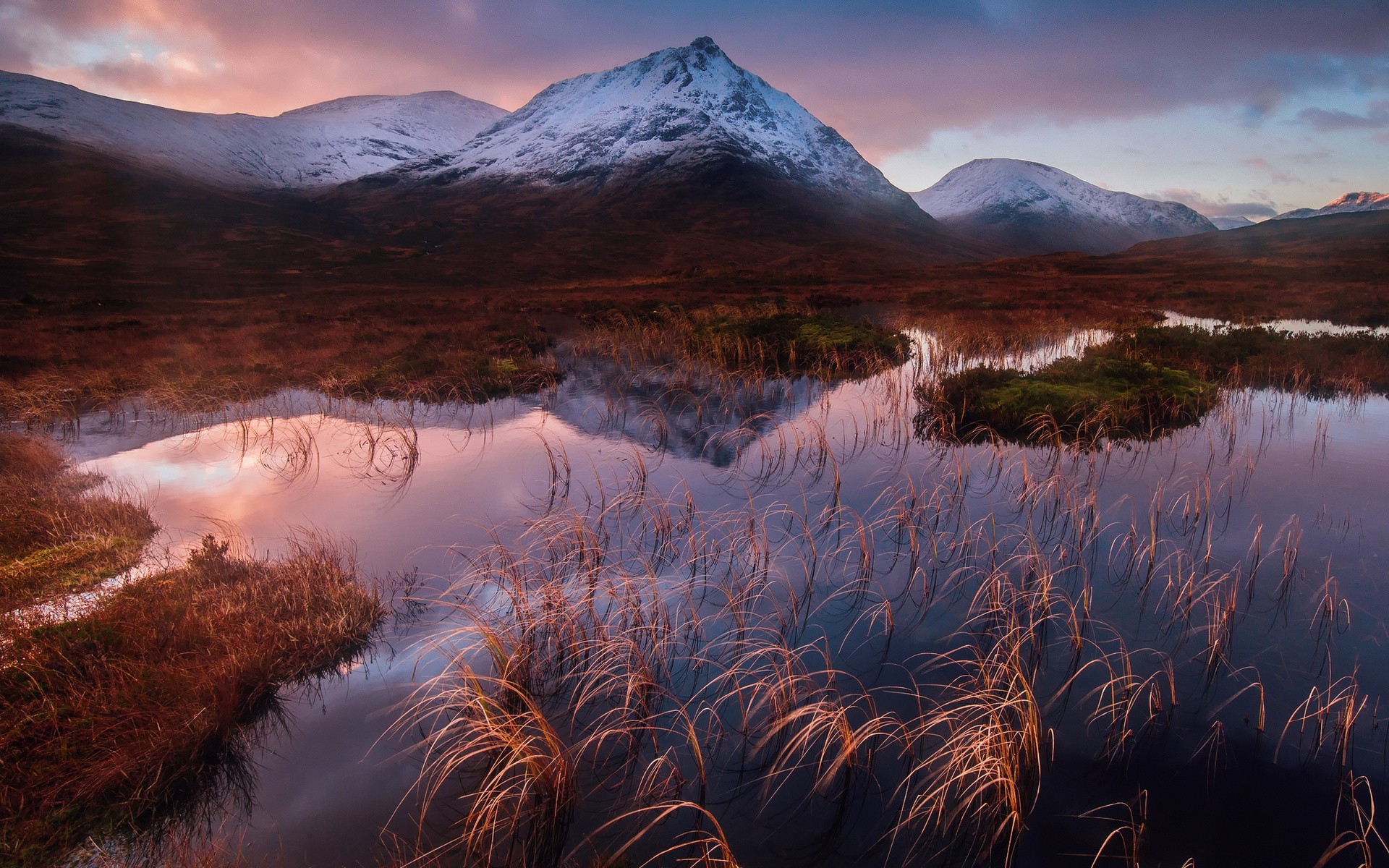 Snow-capped mountains reflected in a calm lake at sunrise HD Wallpaper