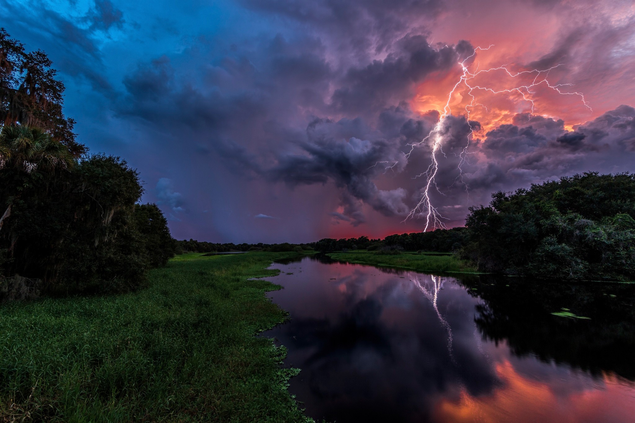 Lightning strikes over a river during a storm HD Wallpaper