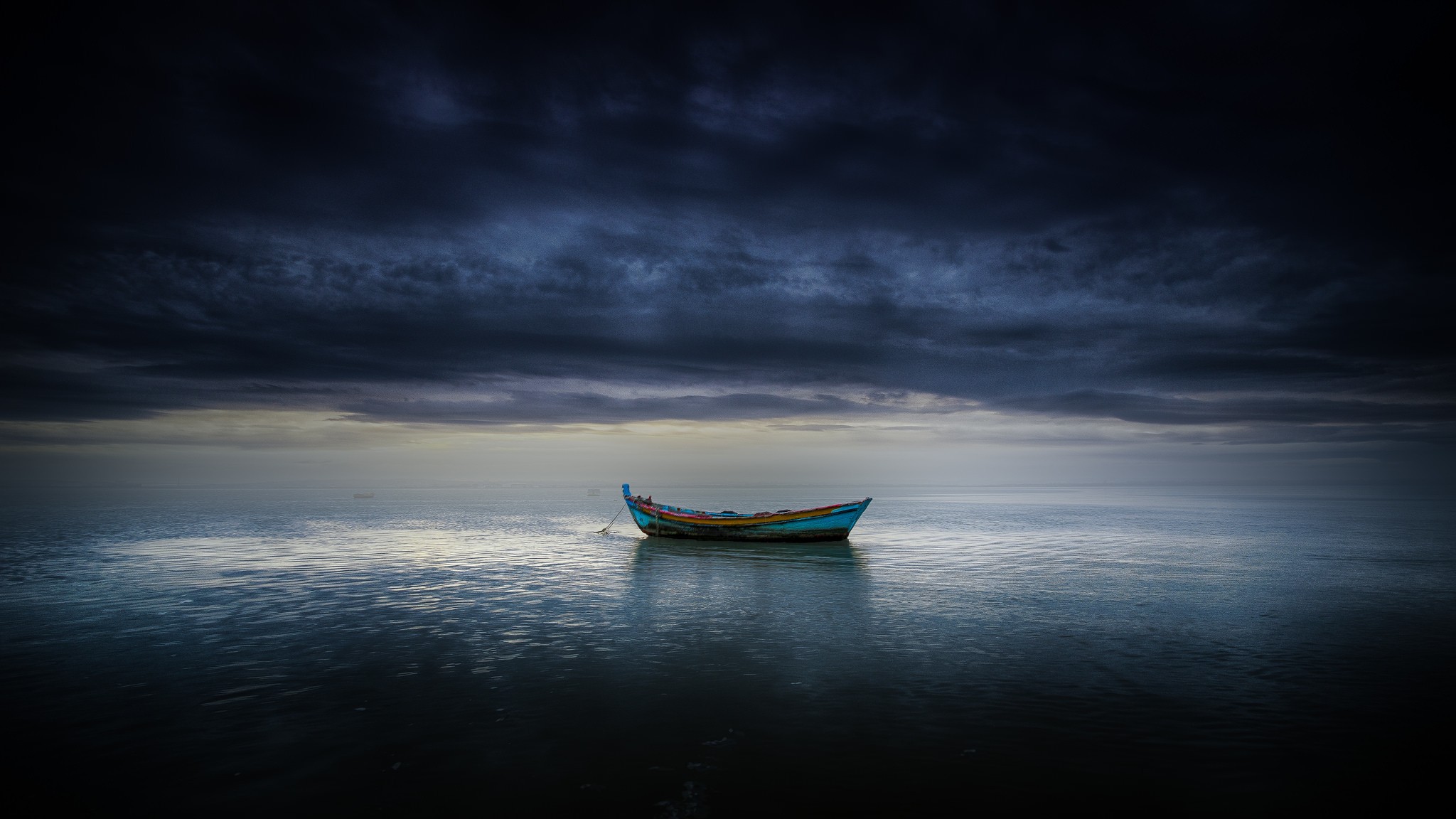 A lone boat on the sea under dark clouds HD Wallpaper
