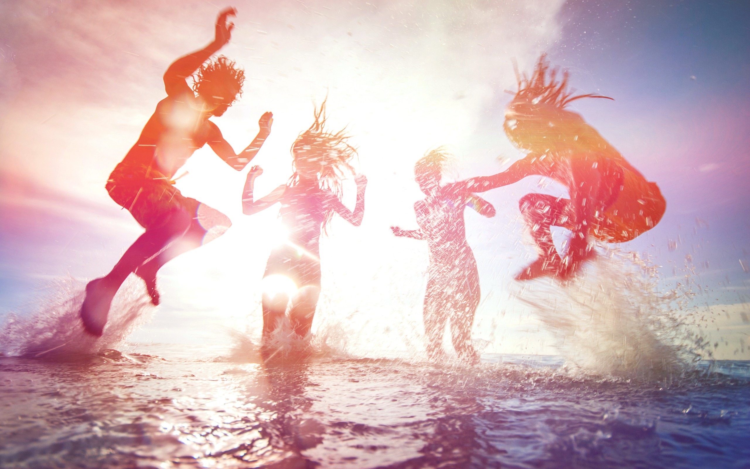 People jumping in the ocean at sunset HD Wallpaper
