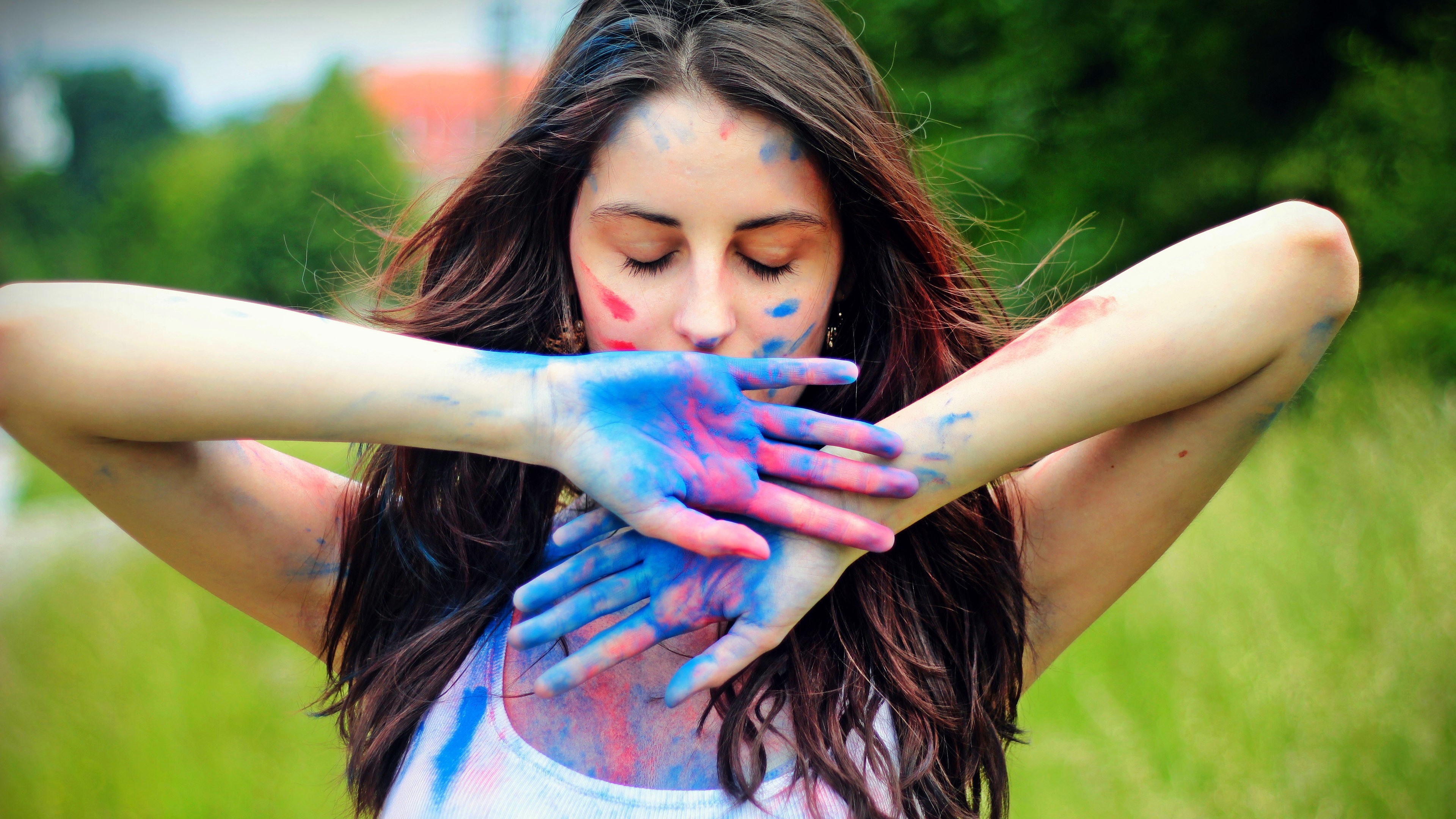 Woman covered in colorful paint with hands in front of face HD Wallpaper