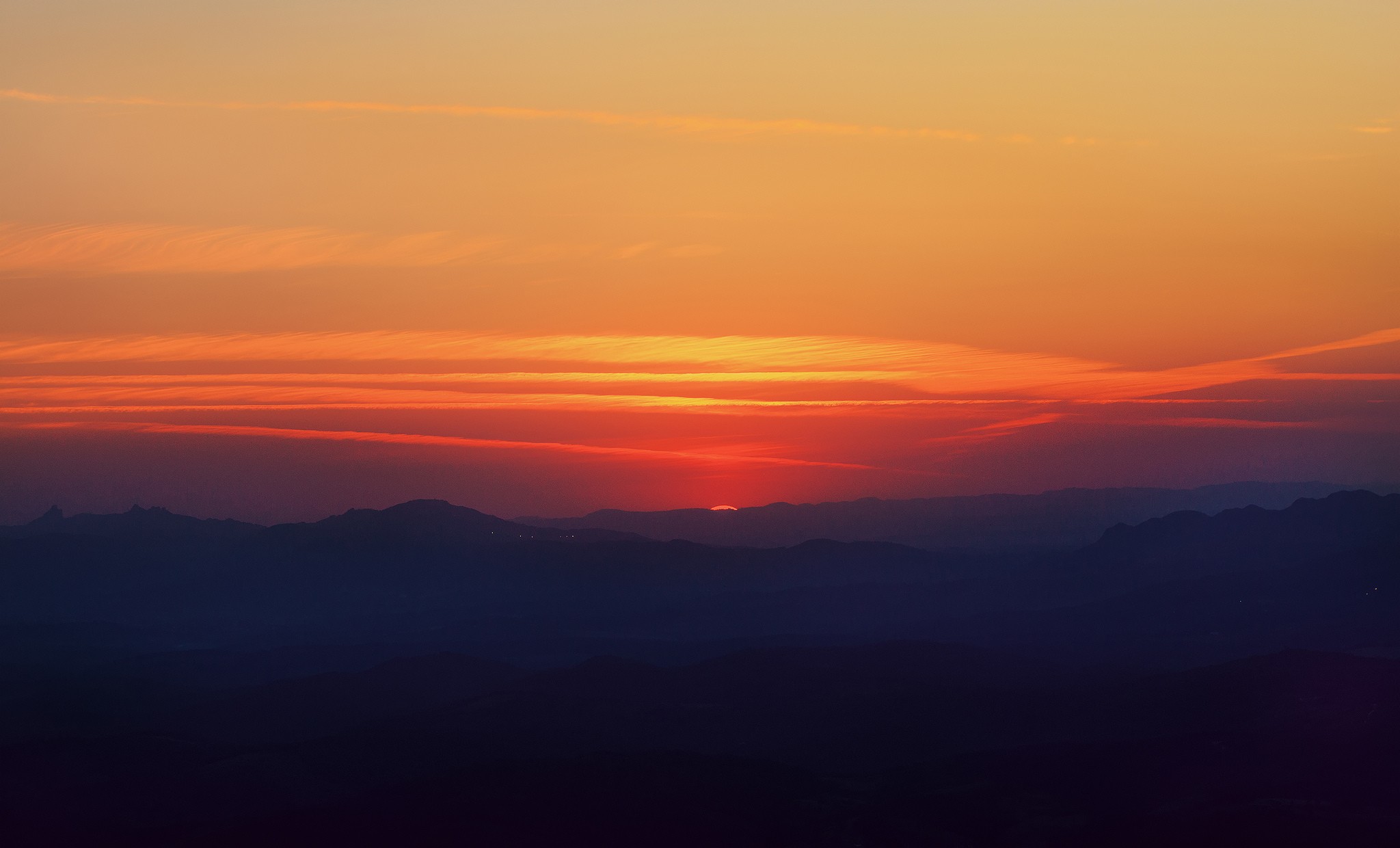 Sunset over silhouetted mountains and orange sky HD Wallpaper