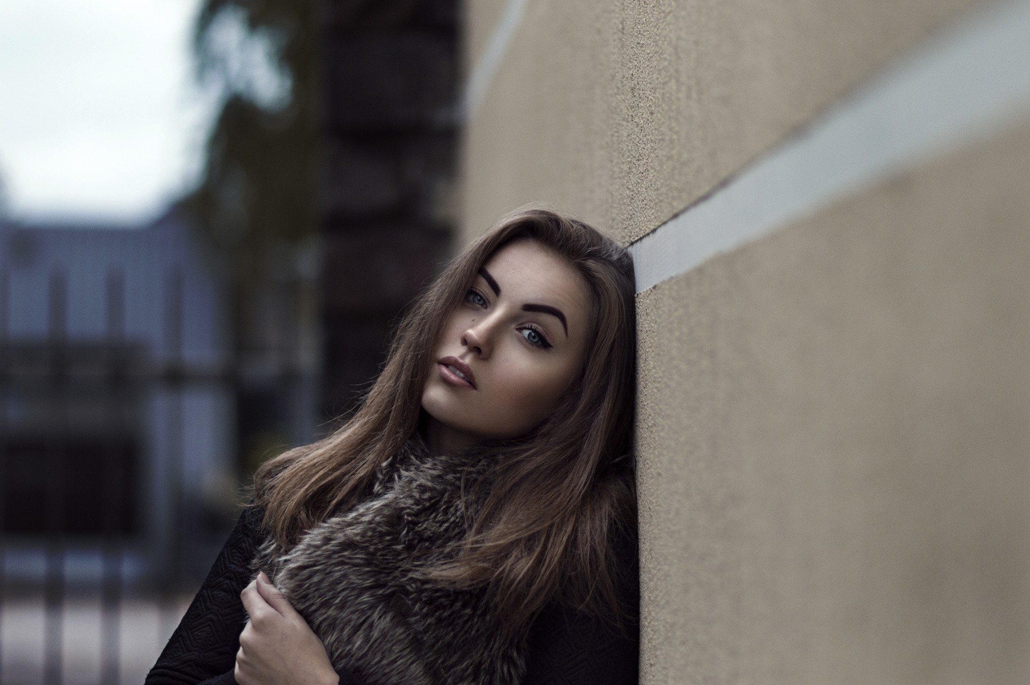 Woman leaning against a wall wearing a fur scarf HD Wallpaper
