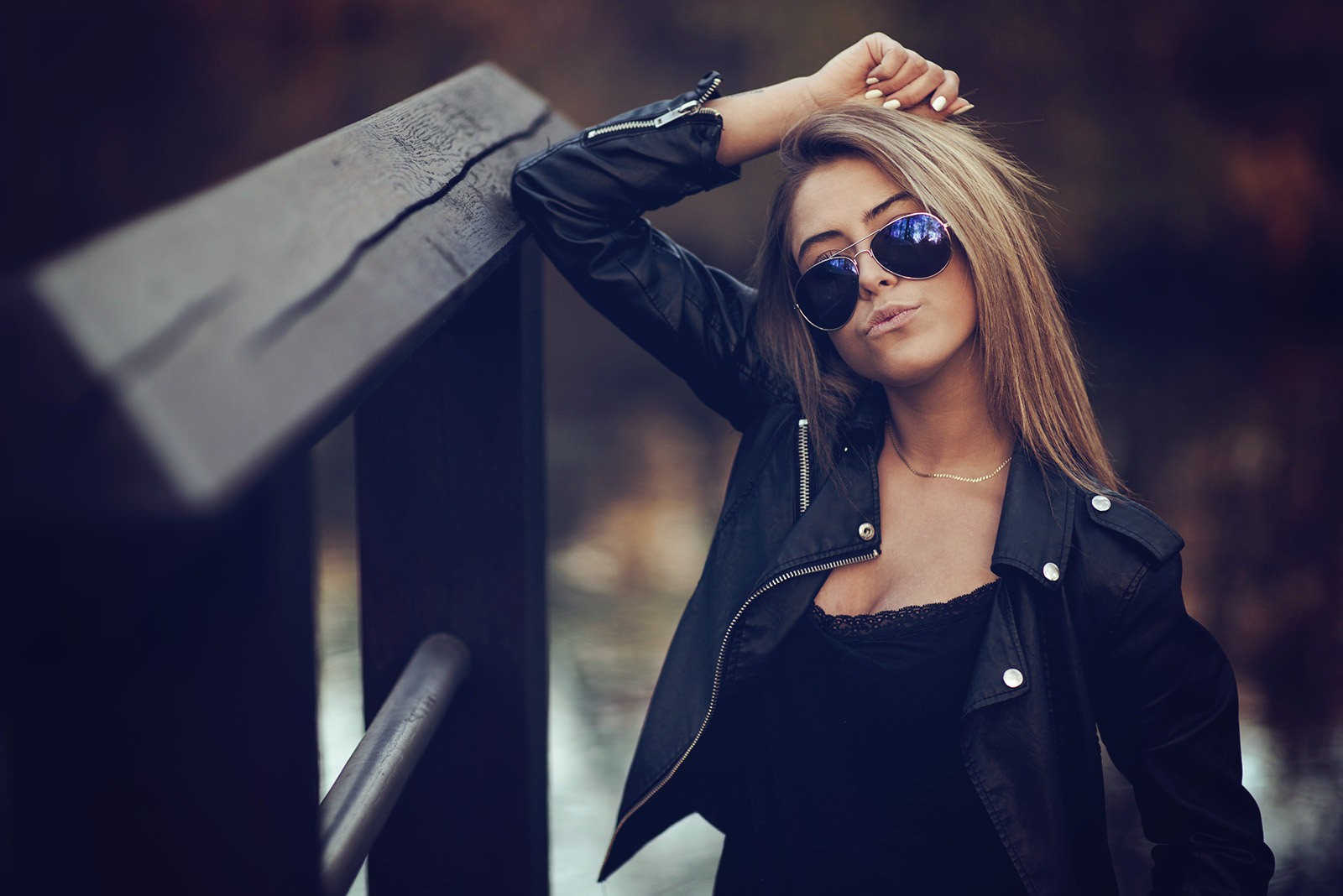 Woman with sunglasses leaning on a wooden railing HD Wallpaper