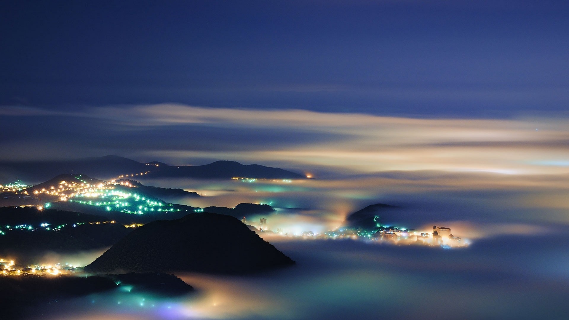 City lights in the mist over mountains at night HD Wallpaper