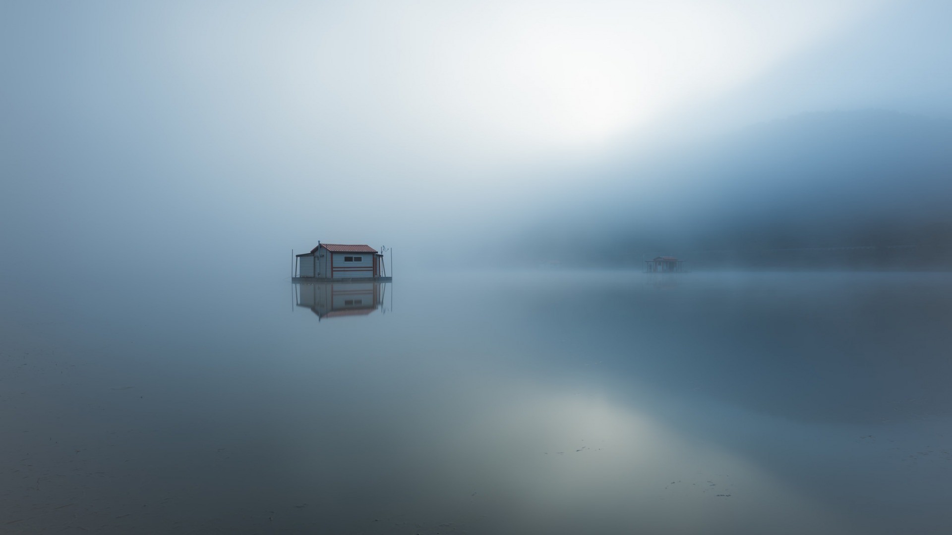Floating house on a misty lake with reflections HD Wallpaper