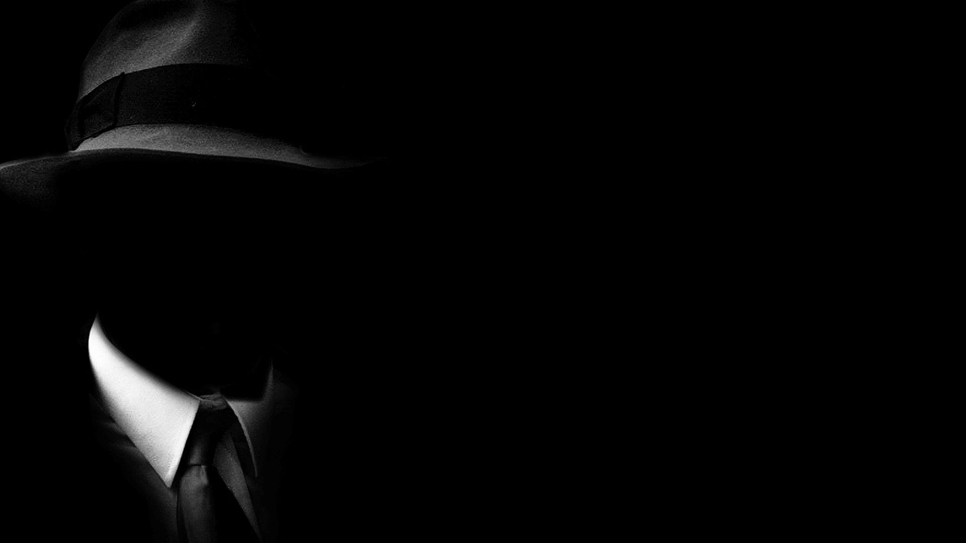 Man in fedora and suit in darkness HD Wallpaper