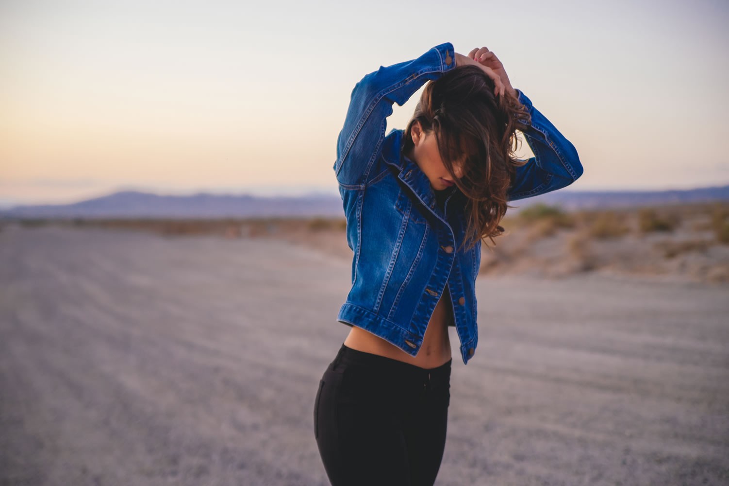 Woman in jean jacket and black pants in desert HD Wallpaper