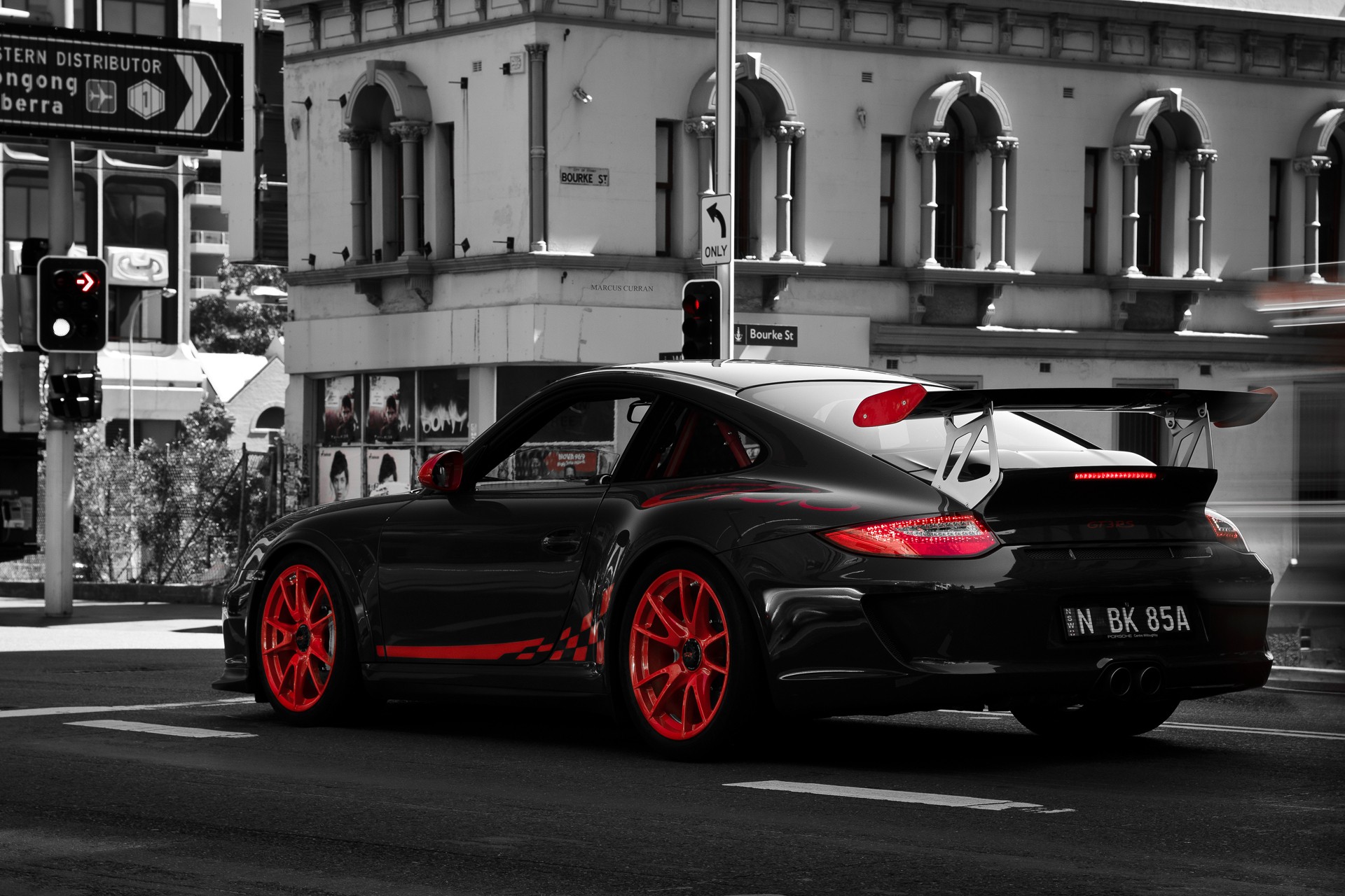 Black Porsche GT3RS with red accents on a city street HD Wallpaper