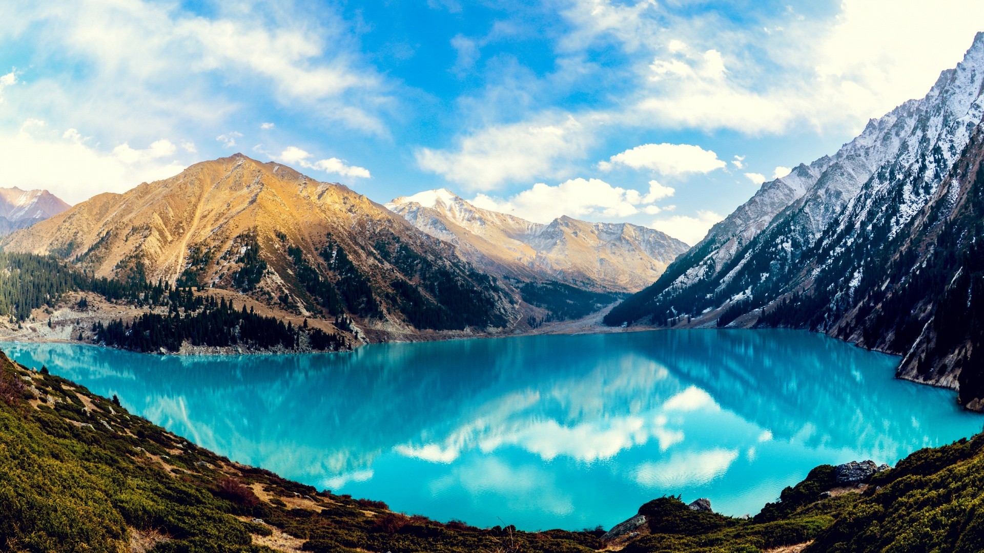 Turquoise lake surrounded by mountains and forests HD Wallpaper