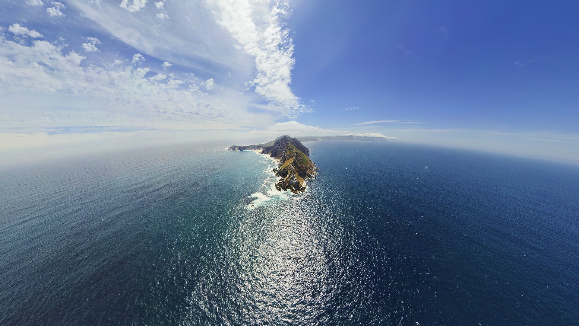 Island jutting into the ocean under a blue sky HD Wallpaper