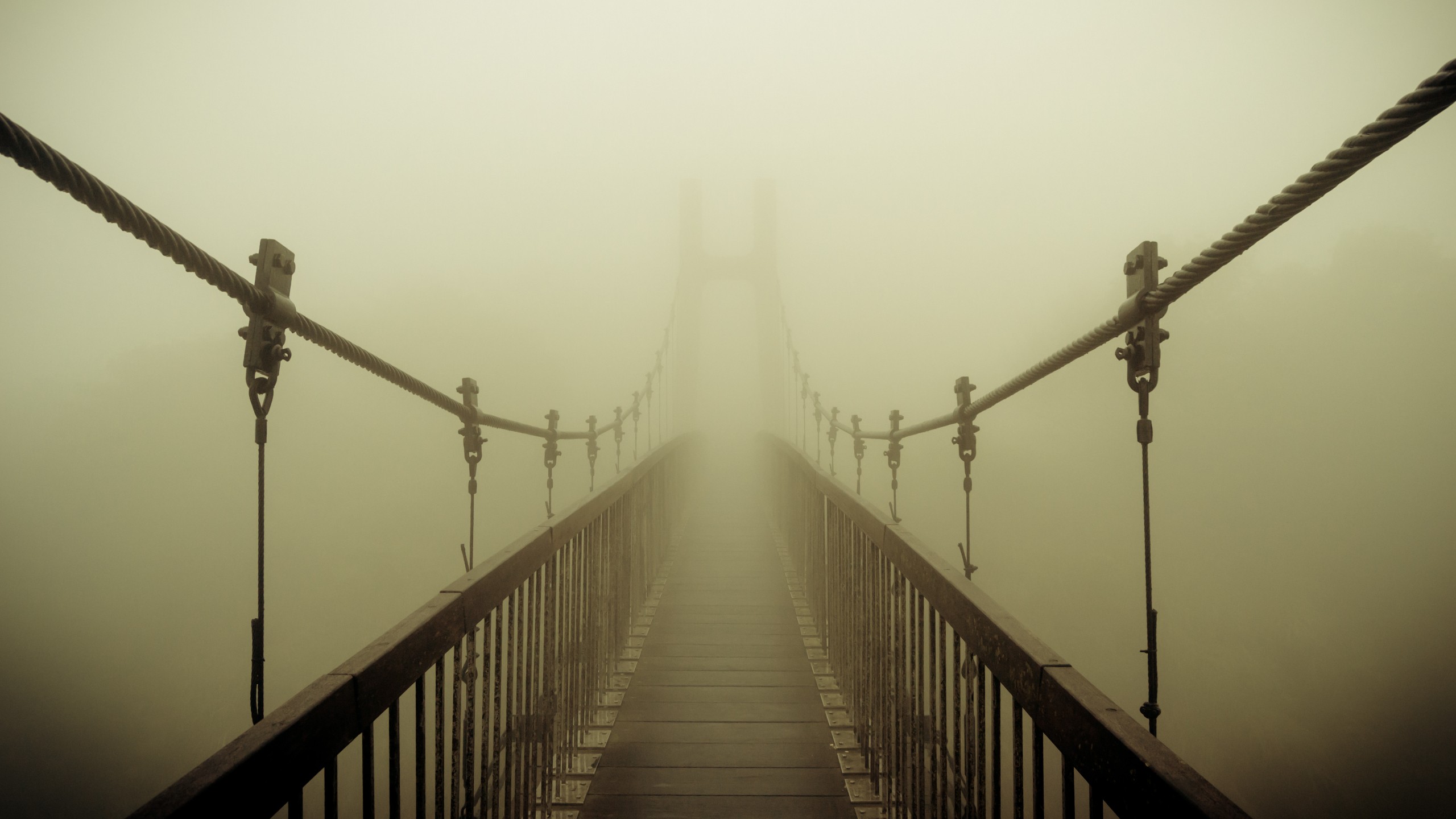 Suspension bridge disappearing into thick fog HD Wallpaper