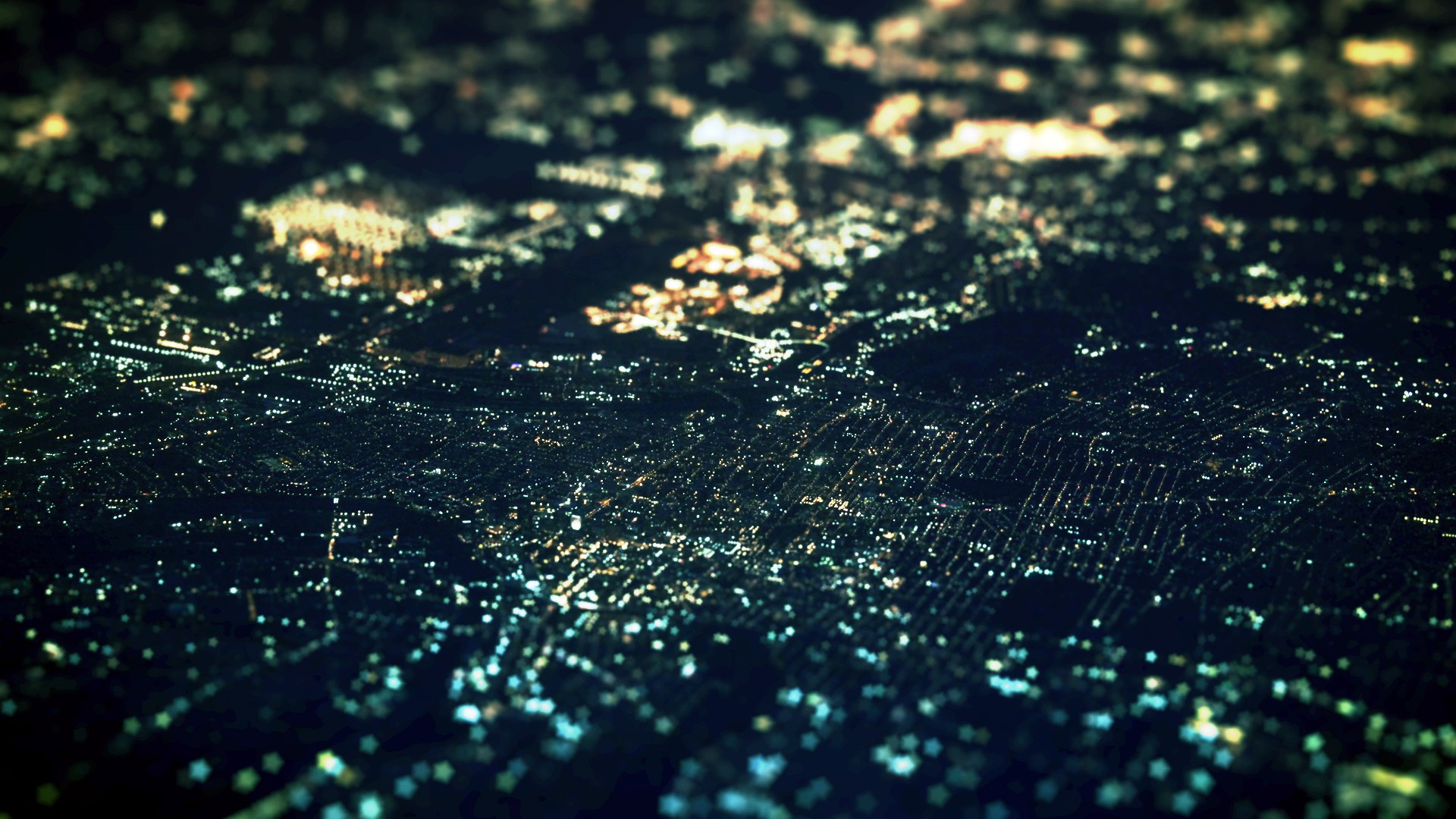 Aerial view of a city at night with tilt-shift effect HD Wallpaper