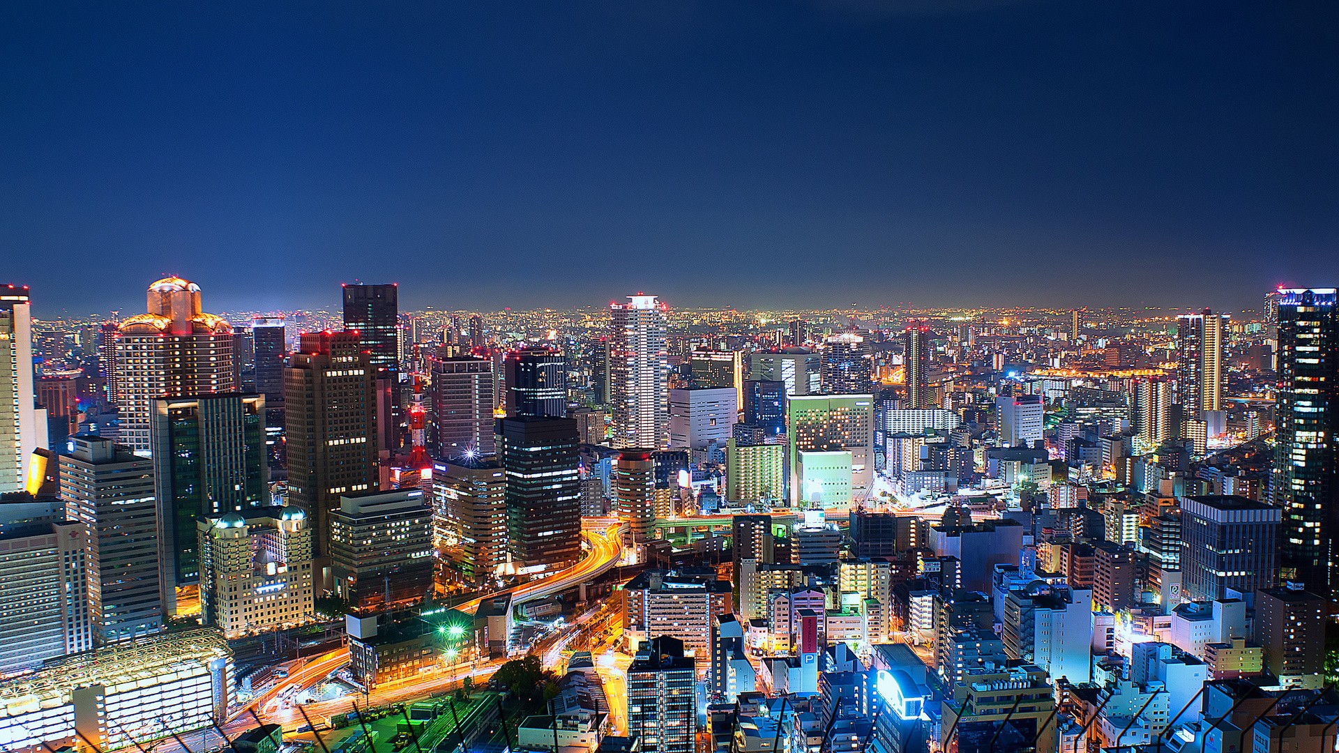 Osaka cityscape at night with illuminated skyscrapers HD Wallpaper