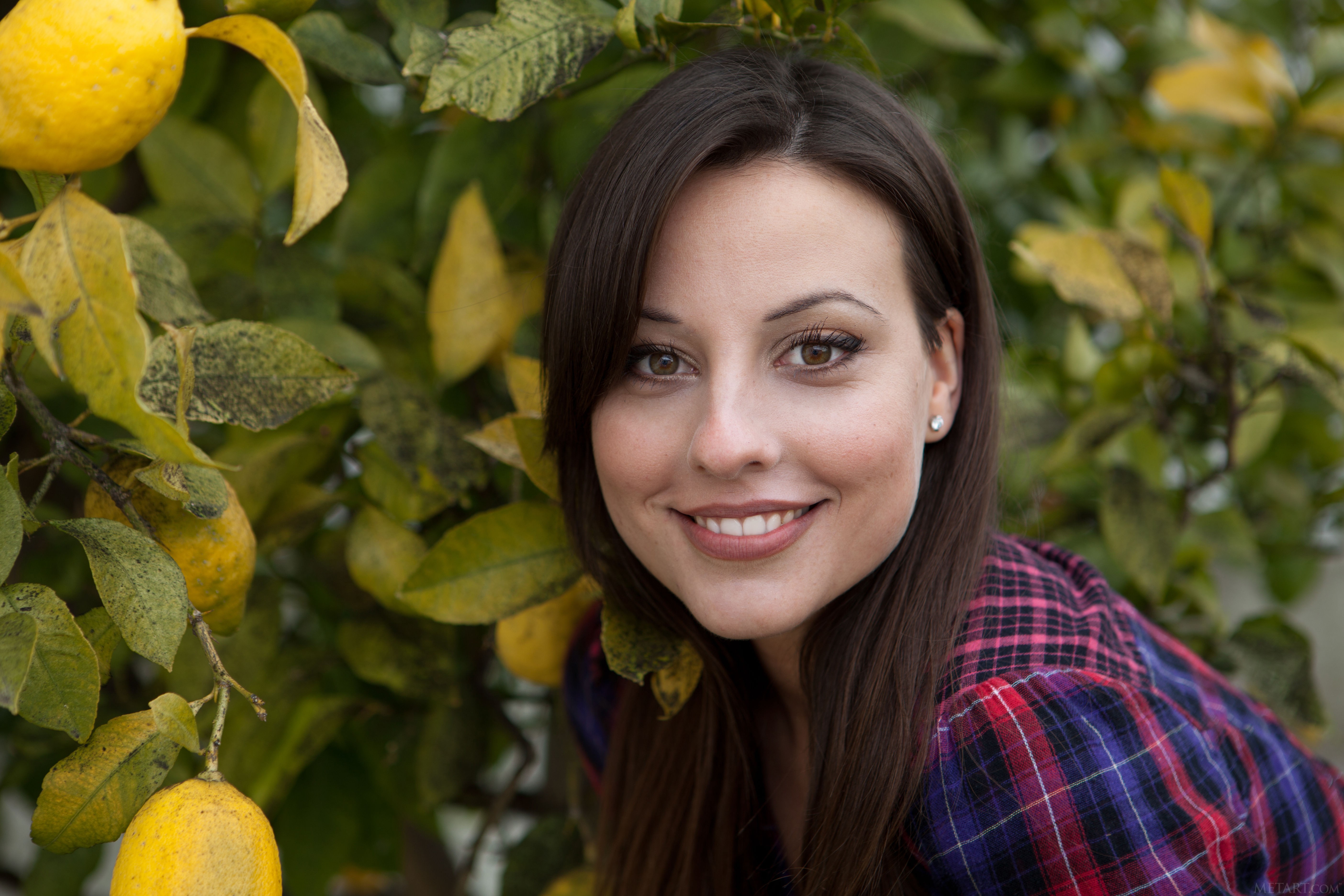 portrait, smiling, looking at viewer, model, women outdoors, face, long hair, plaid shirt, Lorena Garcia, checkered, lemons, brown eyes, leaves, trees, shirt, brunette, women HD Wallpaper
