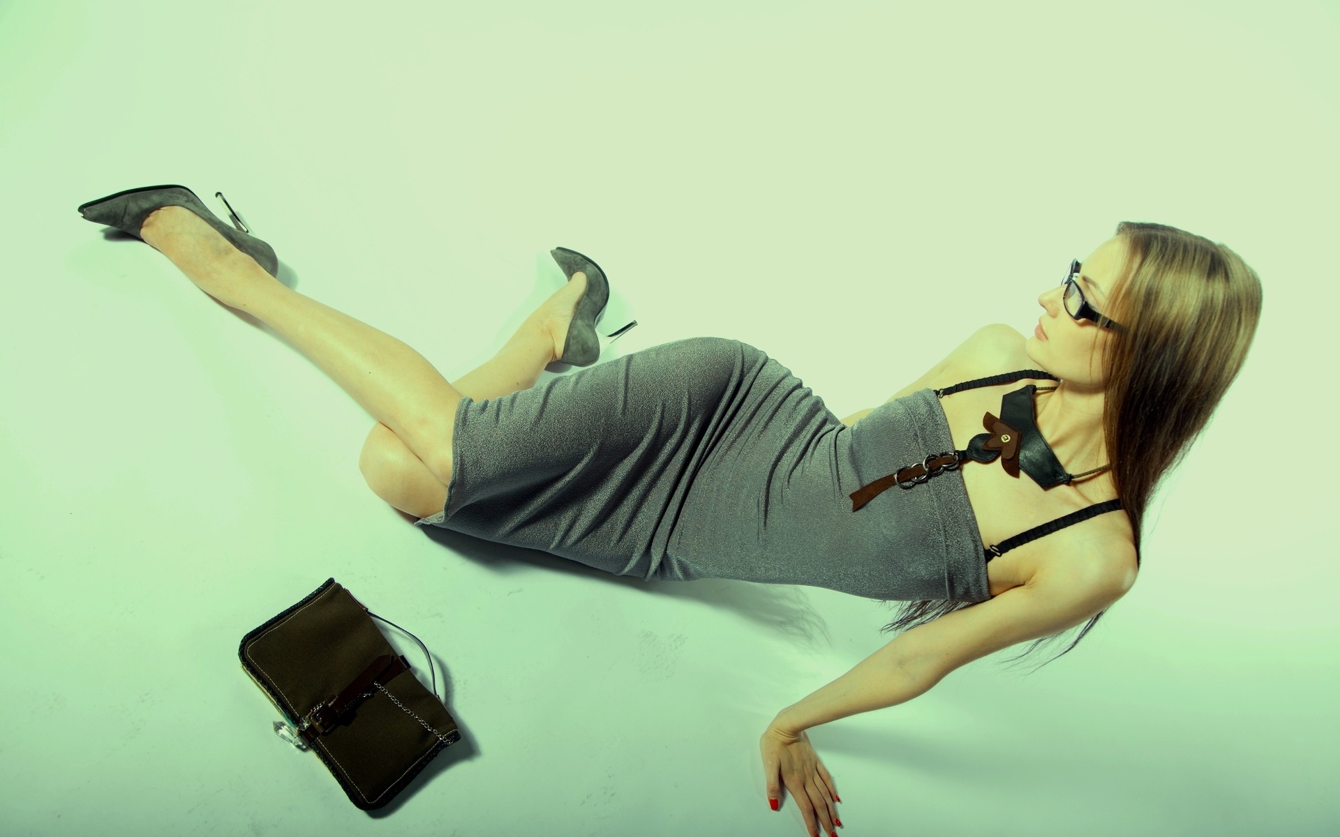 Woman in a gray dress and glasses lying down HD Wallpaper