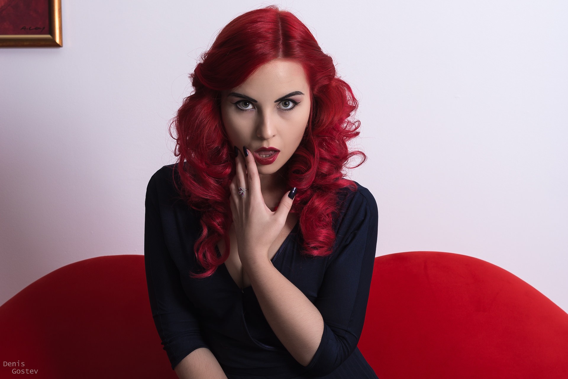 Redhead woman in black dress on red couch HD Wallpaper