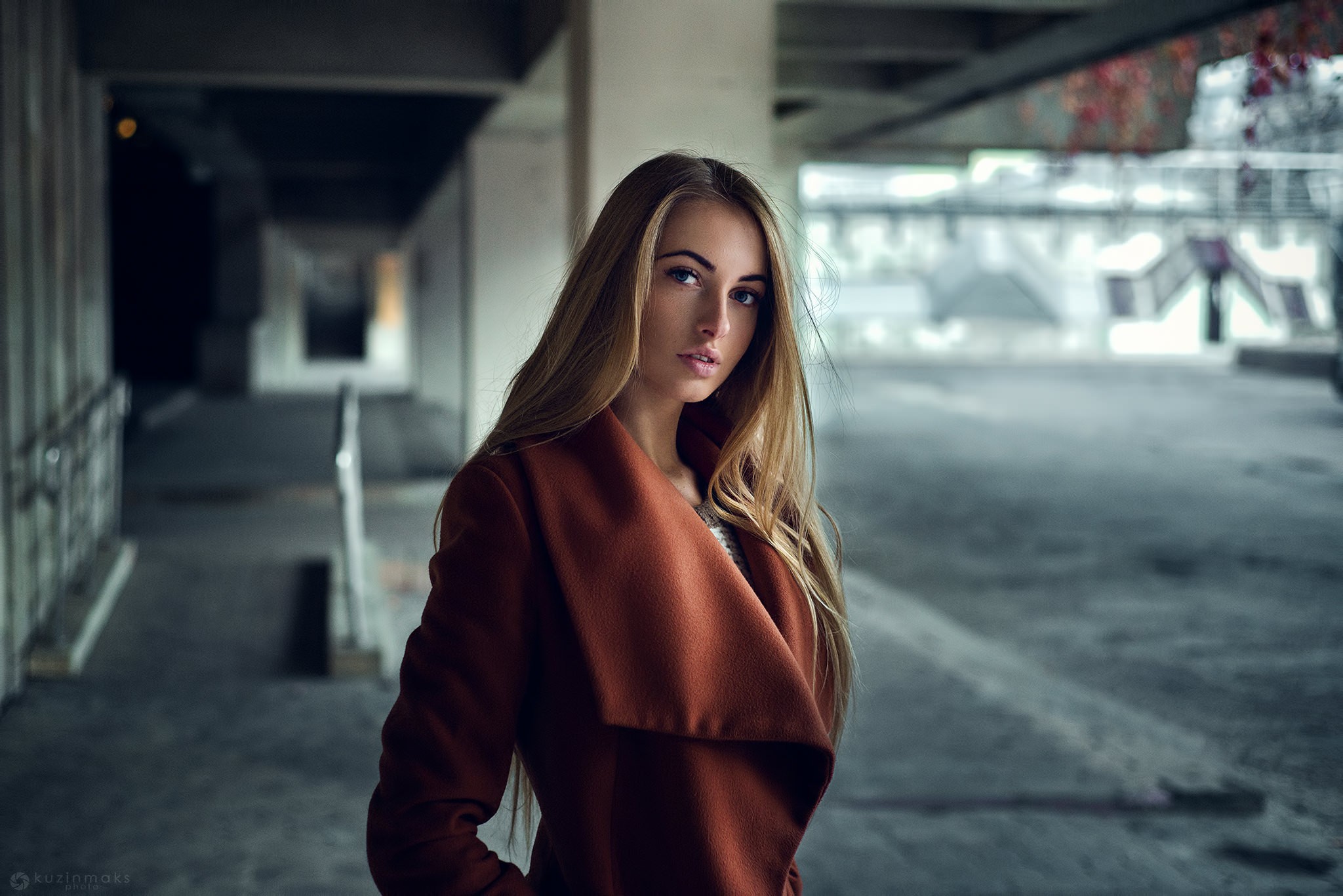Woman in a brown coat standing outdoors HD Wallpaper