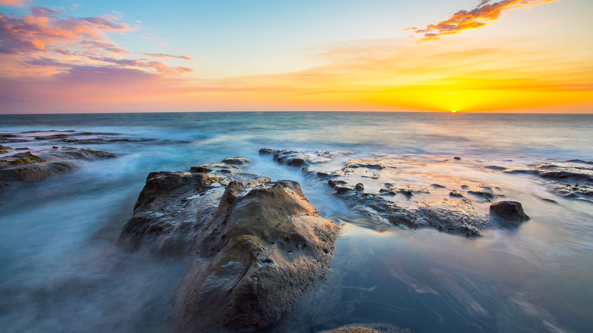 Sunset over the ocean with rocks HD Wallpaper