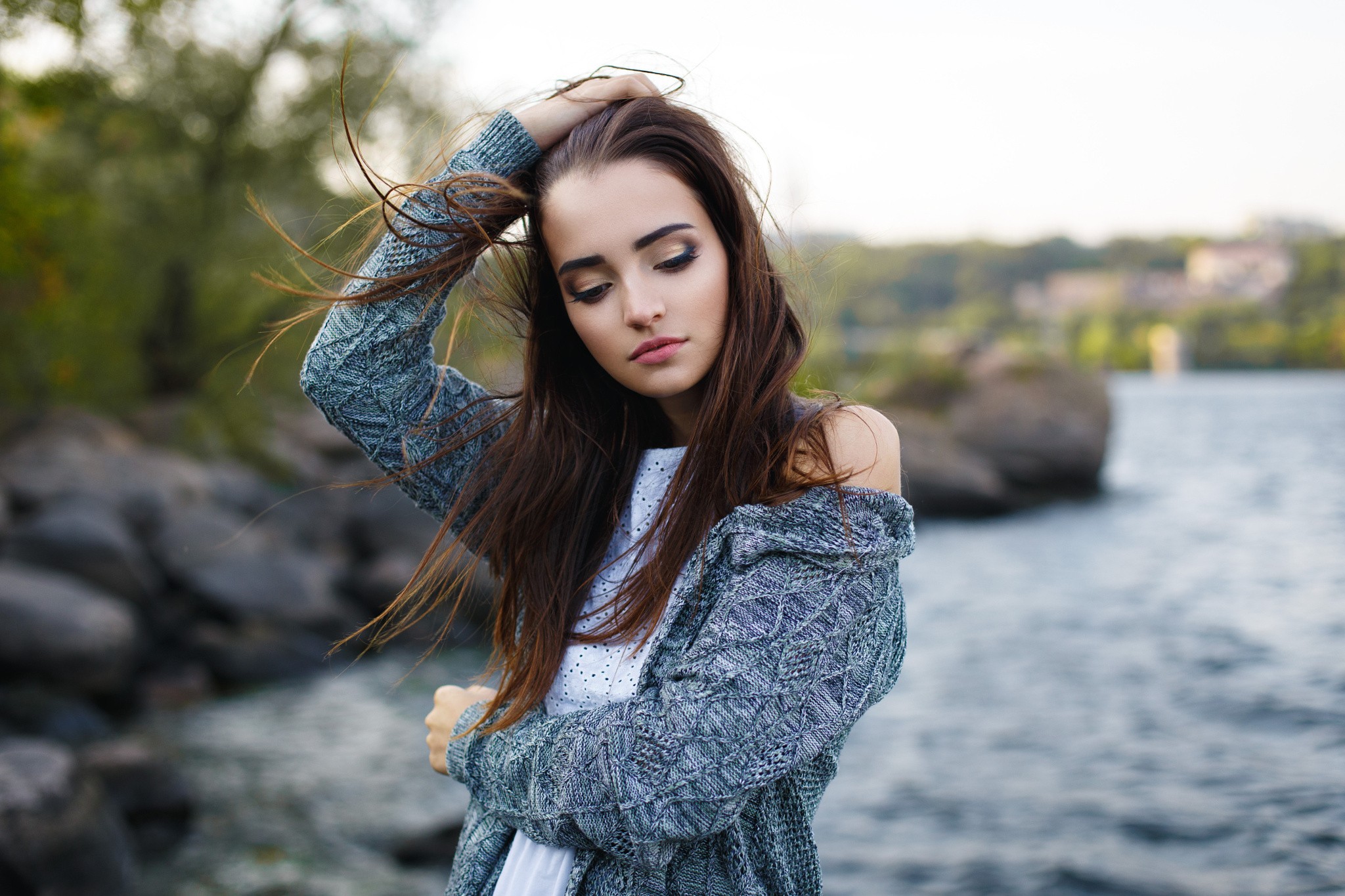 Woman with hands in hair by a river HD Wallpaper