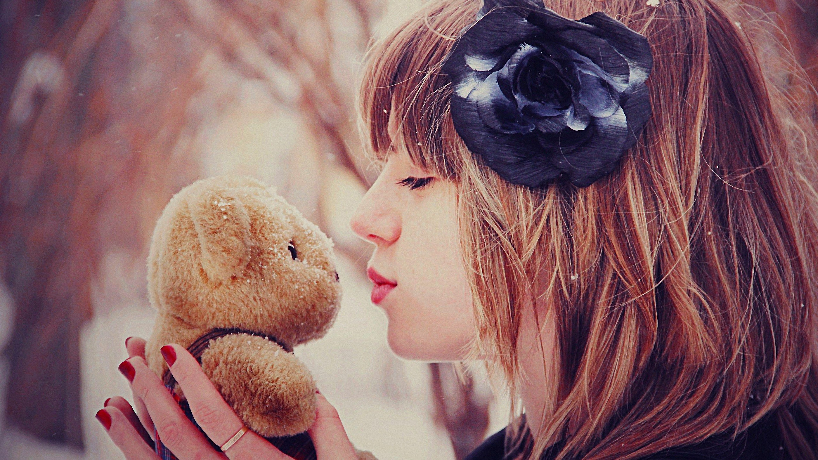 Woman kissing a teddy bear in the snow HD Wallpaper