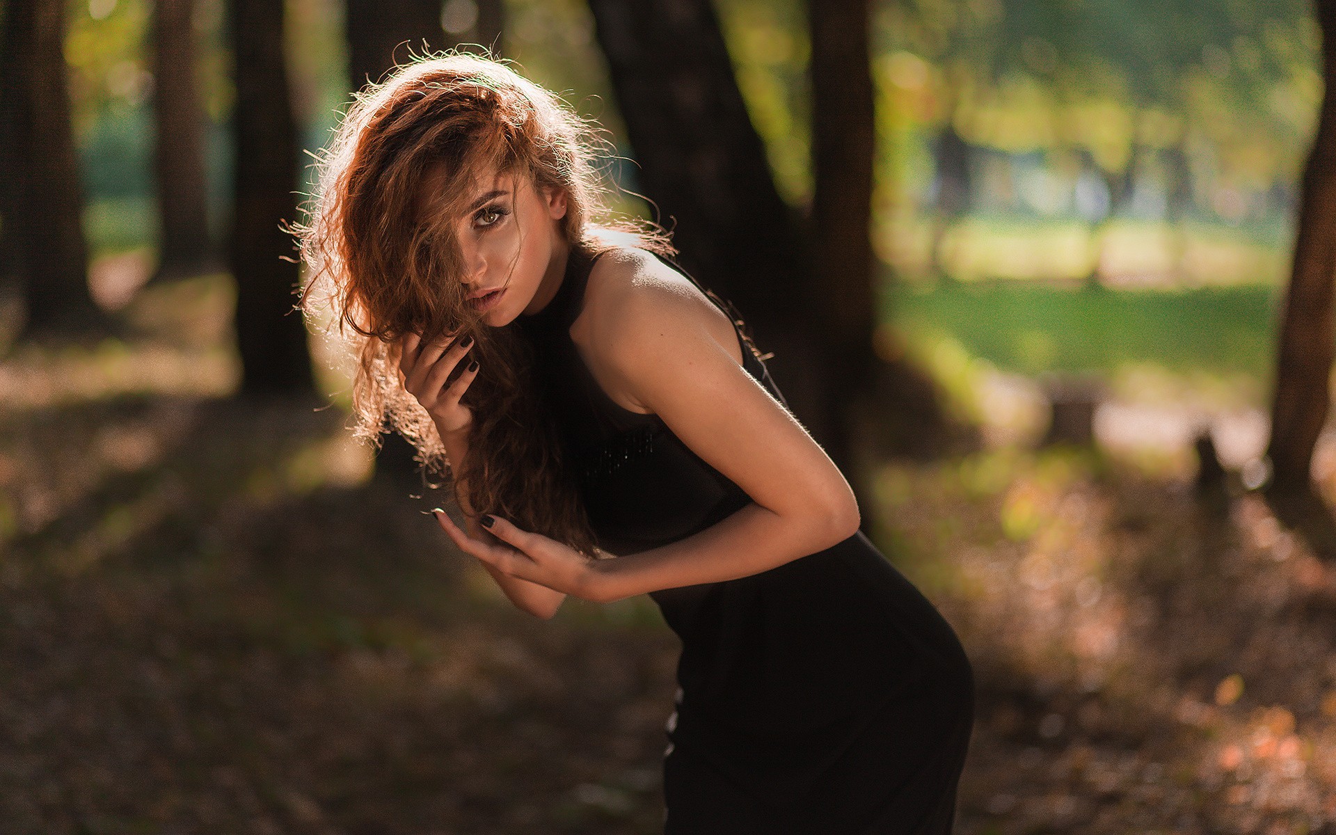 Woman with auburn hair in a black dress outdoors HD Wallpaper