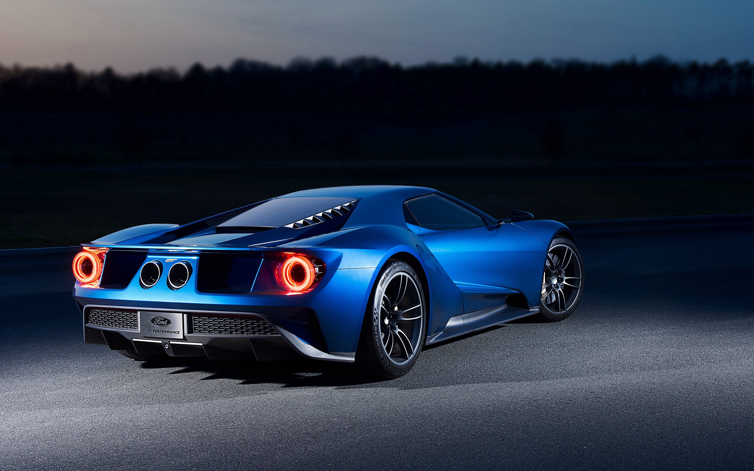 Blue Ford GT car on a race track at dusk HD Wallpaper