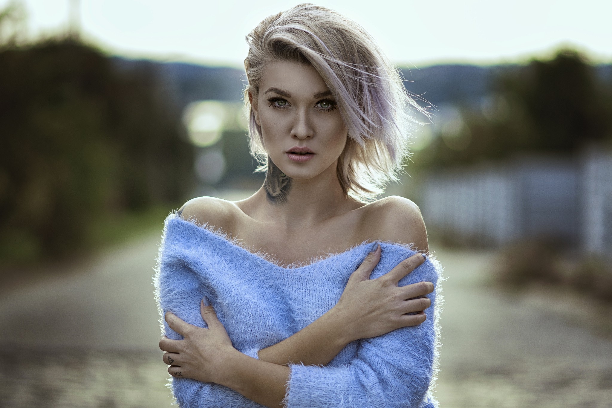 Woman with blonde hair and tattoo wearing a blue sweater HD Wallpaper