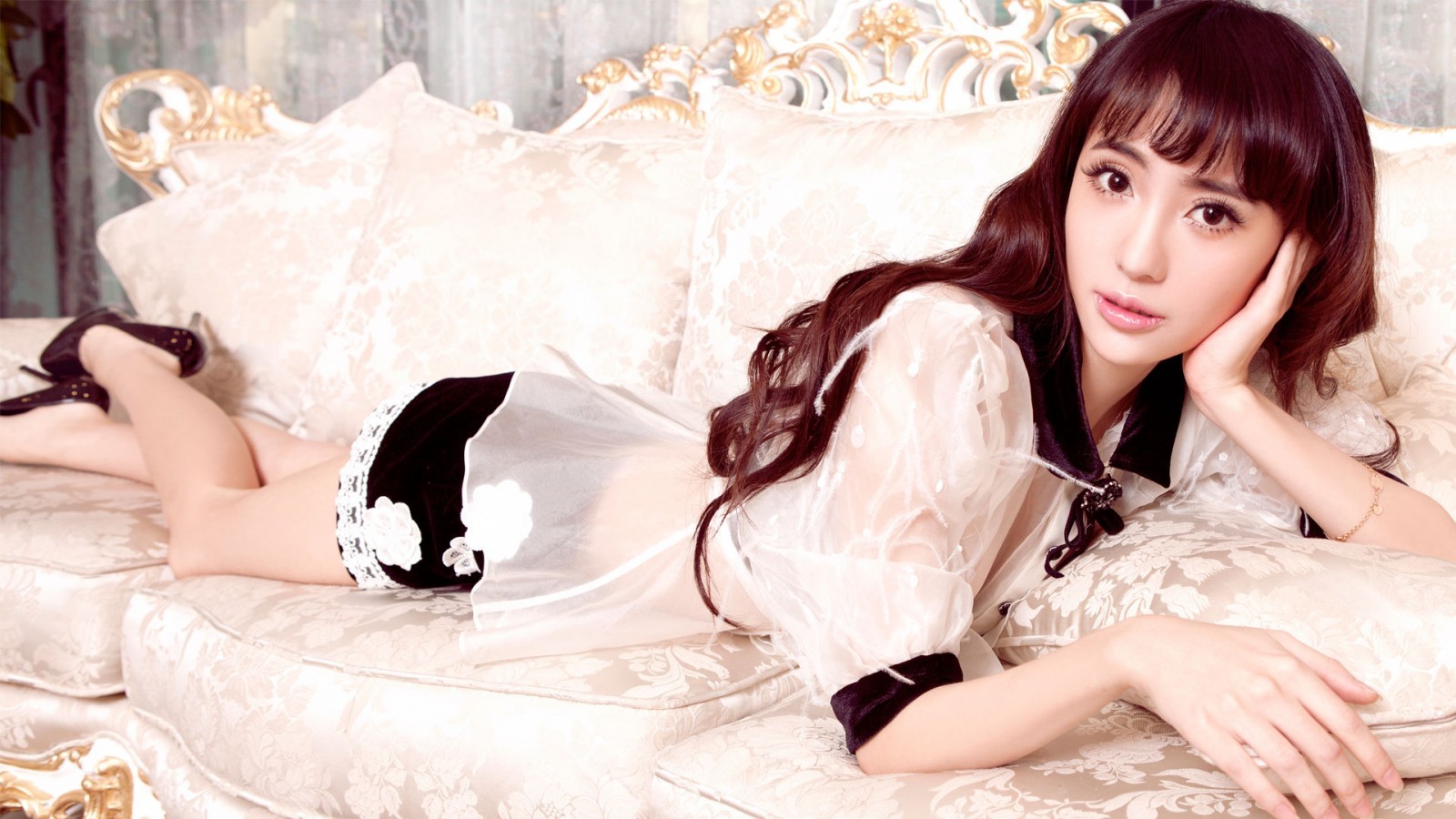 Asian woman lying on a couch HD Wallpaper