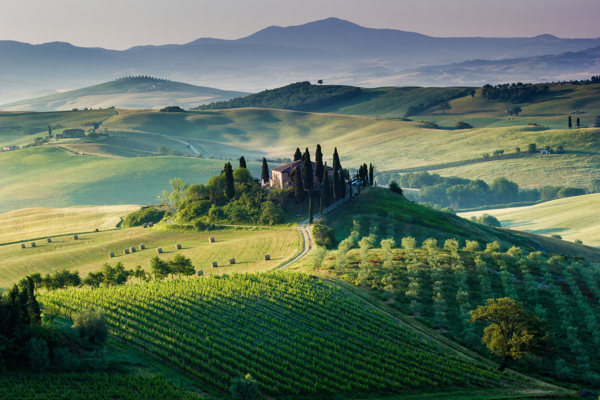 Tuscan landscape with rolling hills and a farmhouse HD Wallpaper